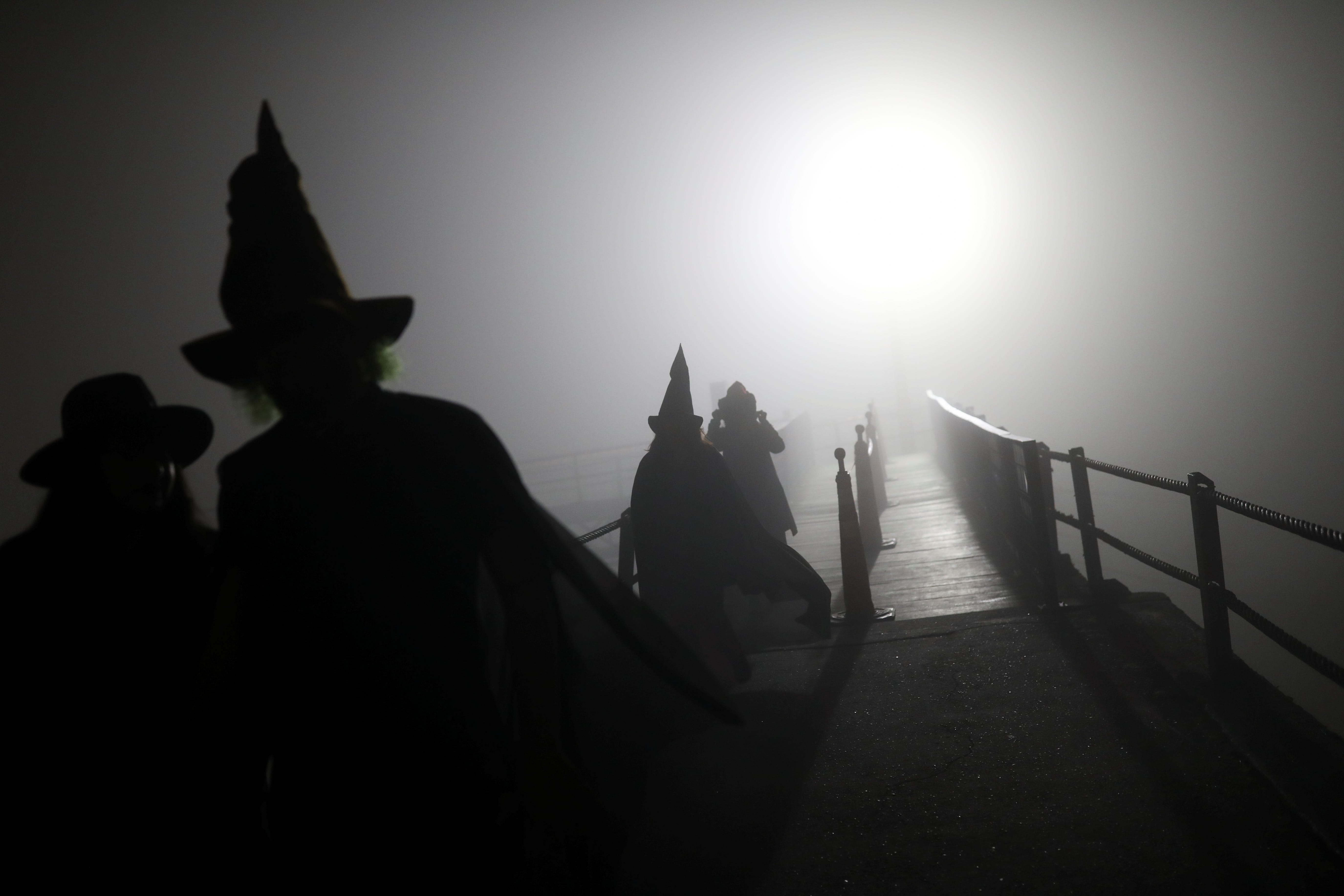 People walk on a footbridge before the opening ceremony of the Witches and Wizards Convention, on Friday the 13th at Paranapiacaba village, in Santo Andre, Brazil May 13, 2022. Picture taken May 13, 2022. REUTERS/Amanda Perobelli