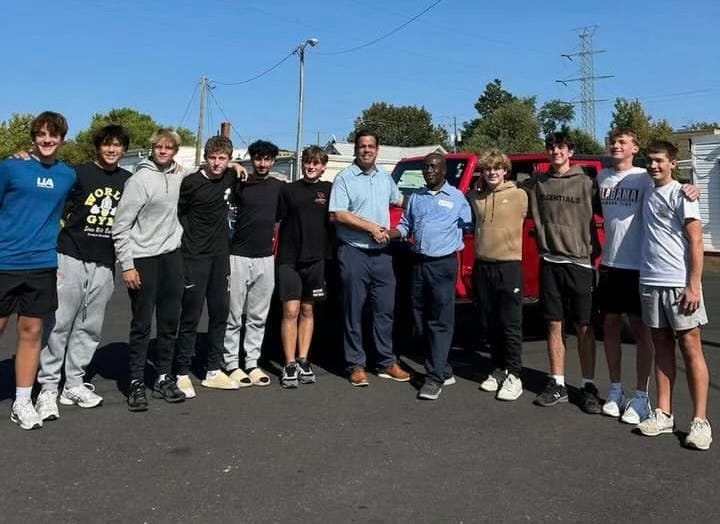 Francis Apraku, a custodian at James Madison High School in Virginia, posing with community members who raised money to buy him a Jeep.