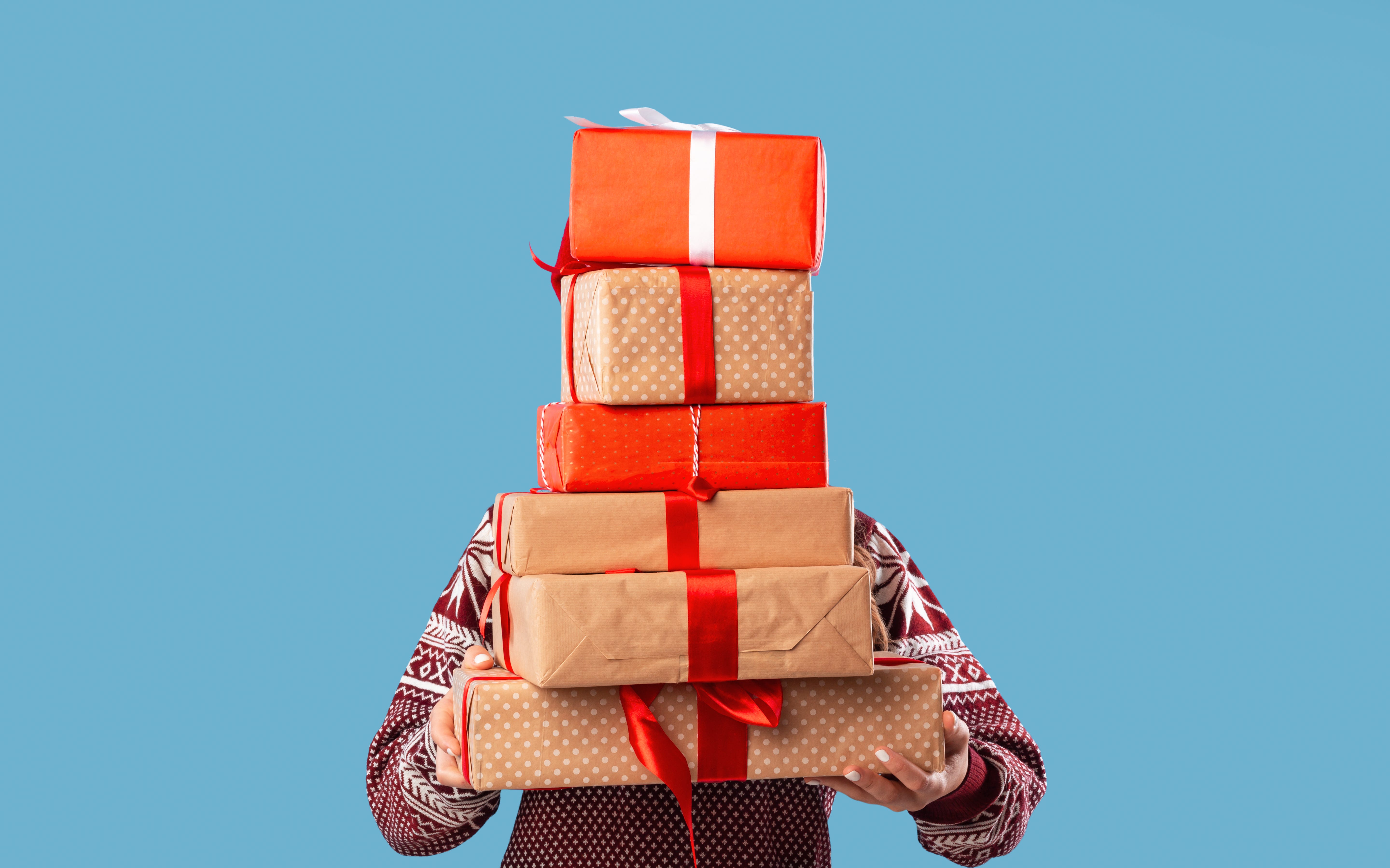 Young woman holding stack of gift boxes.