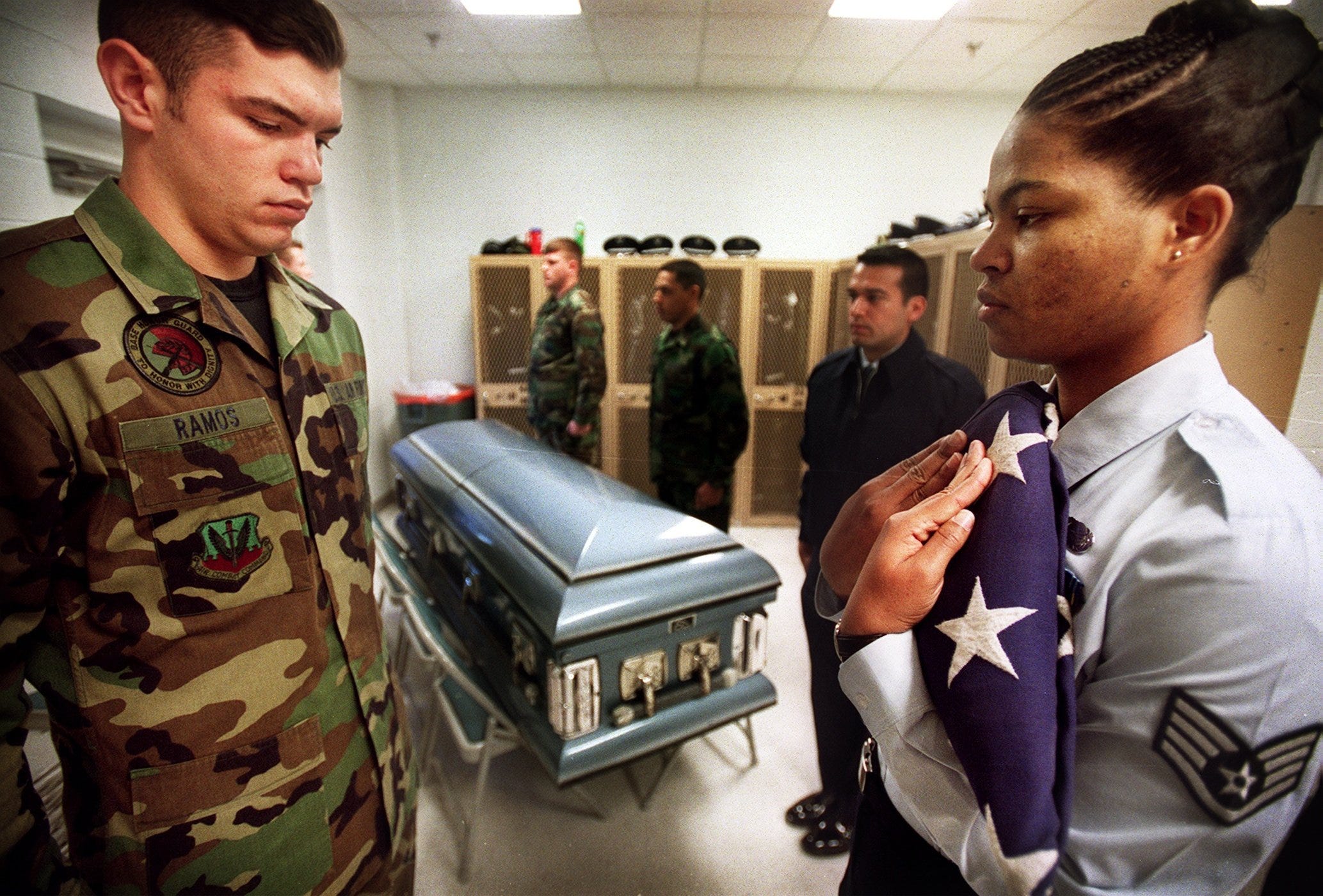 Airmen First Class Nathan Ramos, left, stands as Staff Sgt. Evelyn Davy holds the American flag at a practice for a military funeral at Pope Air Force Base.