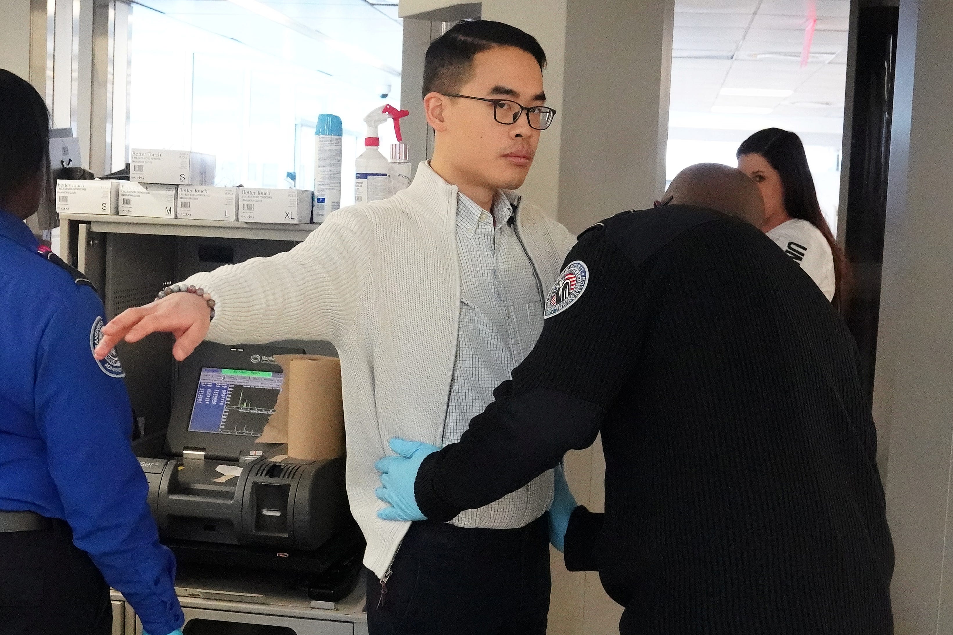 A TSA agent checks passengers at a security checkpoint at LaGuardia Airport in the Queens borough of New York City, New York on January 31, 2019.