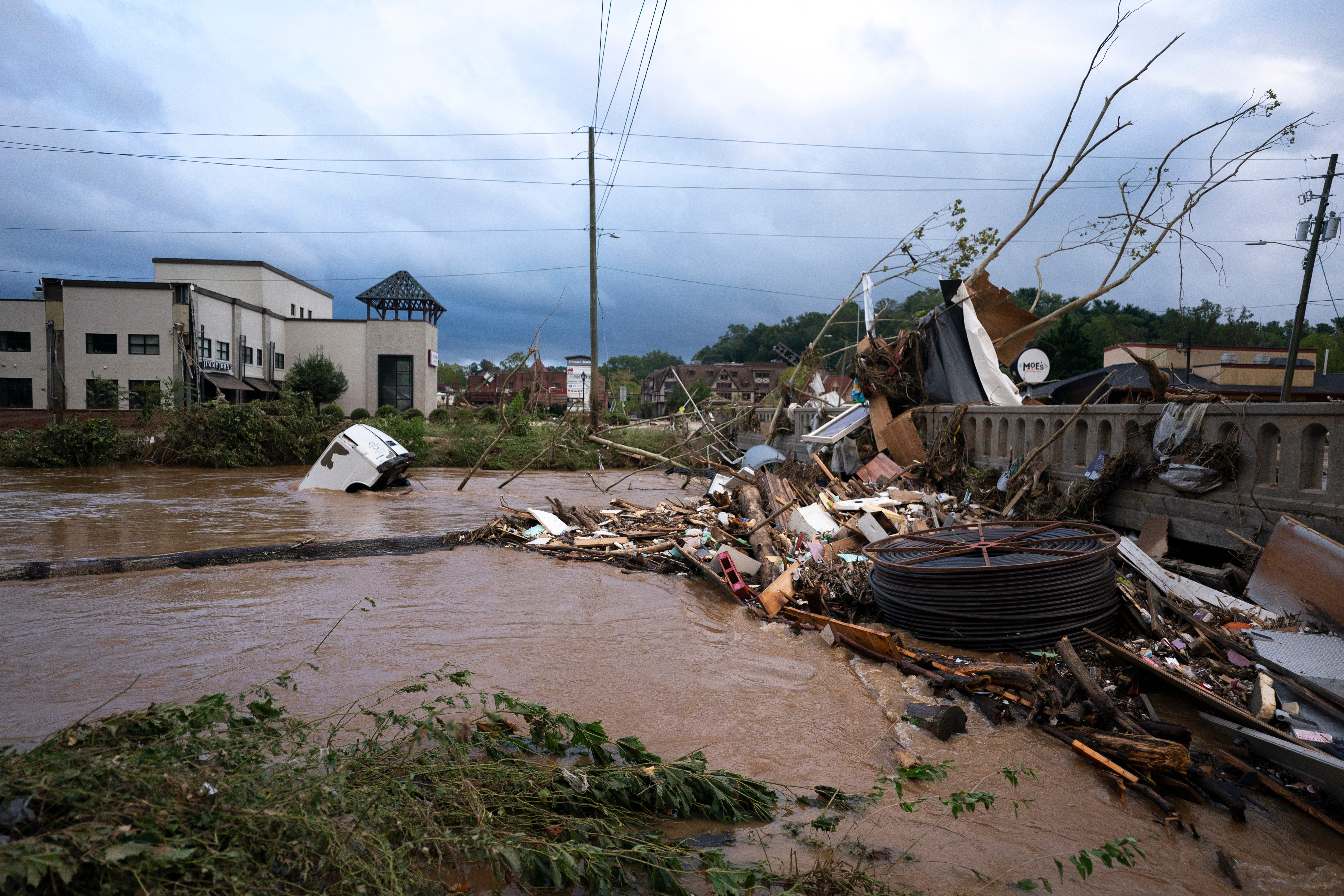 A van flows in floodwaters near the Biltmore Village in the aftermath of Hurricane Helene on September 28, 2024 in Asheville, North Carolina. Hurricane Helene made landfall Thursday night in Florida's Big Bend with winds up to 140 mph.