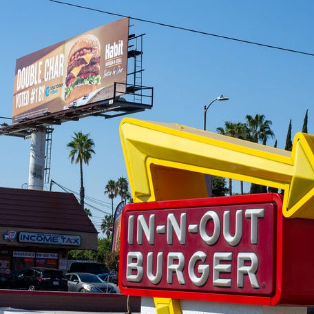 A billboard touting The Habit's ranking number one in a USA TODAY 10 BEST list is seen next to an In-N-Out location in the Van Nuys neighborhood in Los Angeles, Calif. on Tuesday, October 1, 2024.