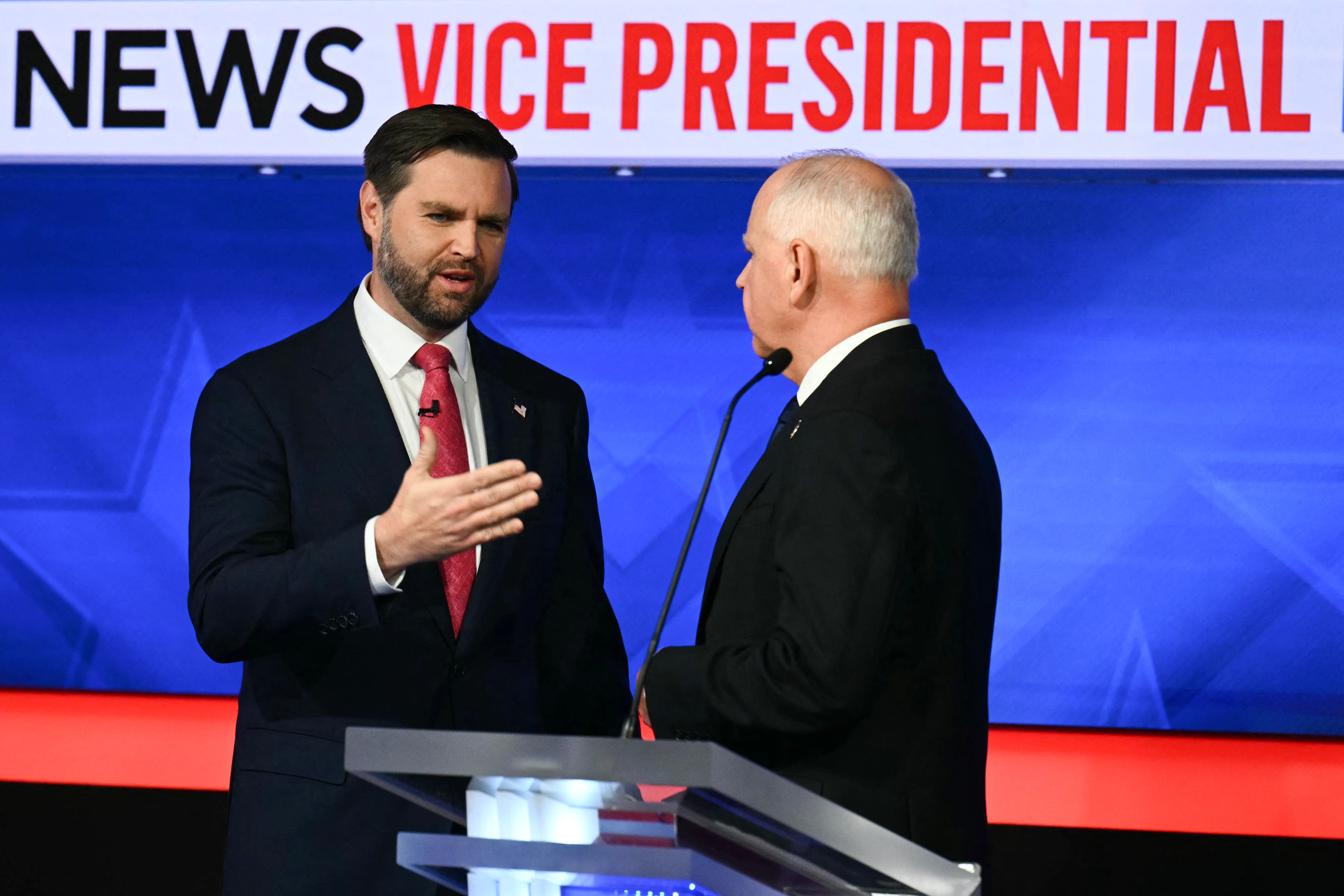 US Senator and Republican vice presidential candidate J.D. Vance (L) and Minnesota Governor and Democratic vice presidential candidate Tim Walz talk with each other at the end of the Vice Presidential debate hosted by CBS News at the CBS Broadcast Center in New York City on October 1, 2024.