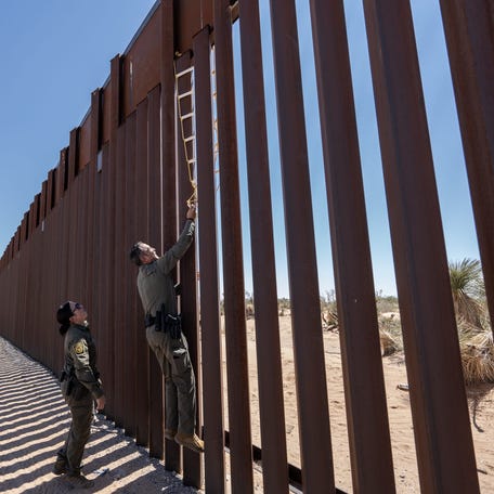 Border Patrol Agent Claudio Herrera tries to dislodge a homemade latter used by migrants to climb the border wall in the desert in Santa Teresa, New Mexico.