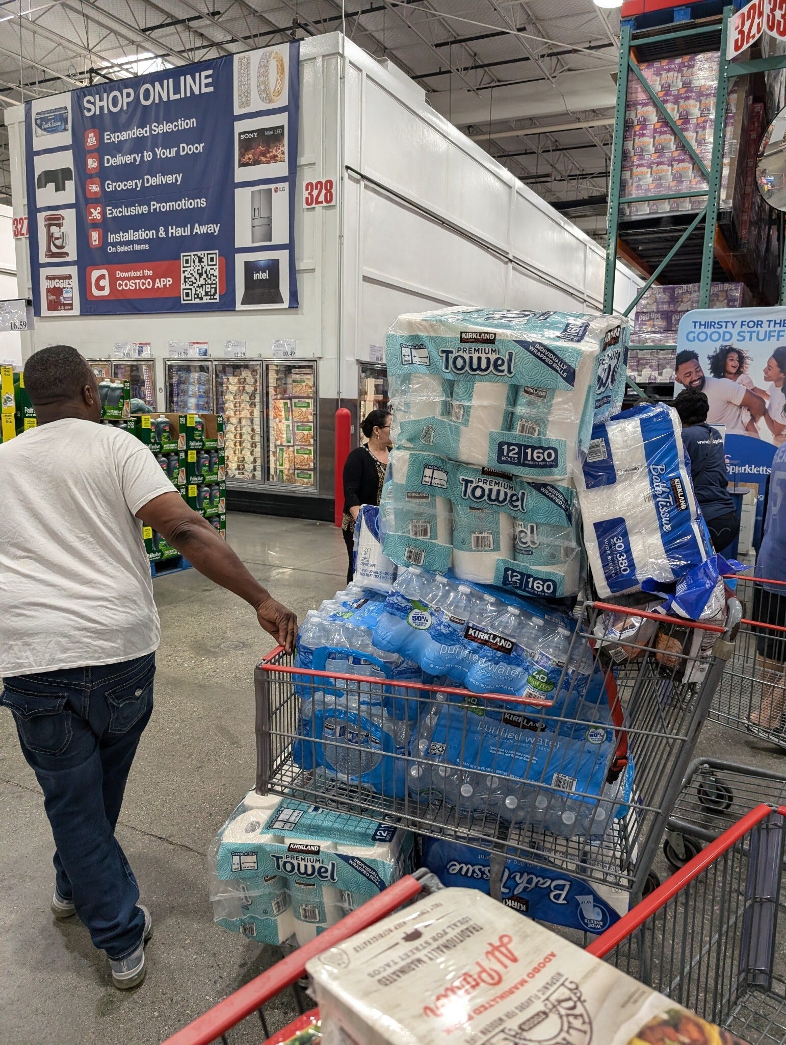 A Costco shopper in Inglewood, California, stocks up on water, toilet paper and paper towels a day after the East Coast port strike began.