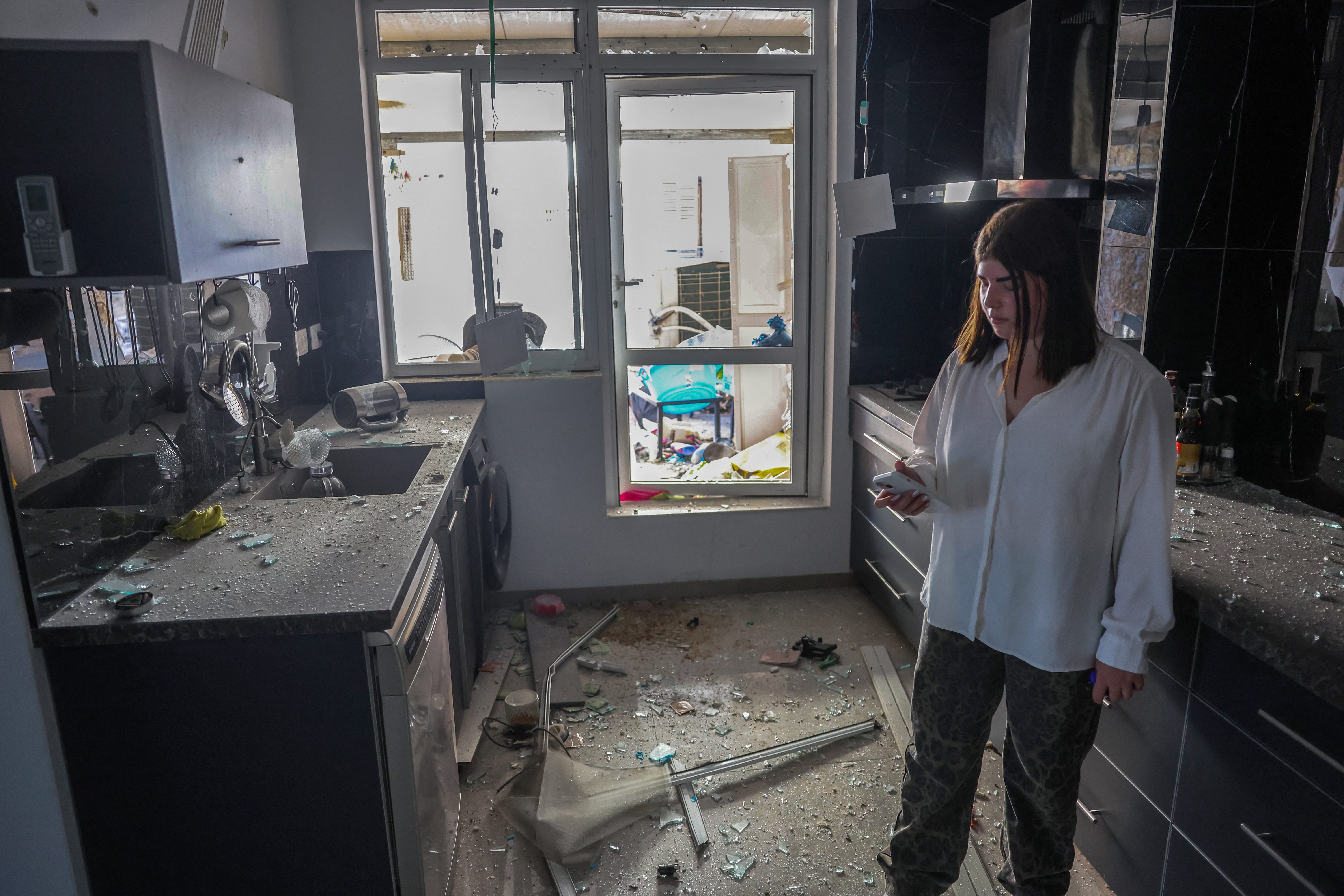 A woman inspects a damaged apartment in a building hit with a rocket launched from Lebanon on Oct. 8, 2024, after Hezbollah fired more than 100 missiles into Haifa, Israel, and its northern suburbs.