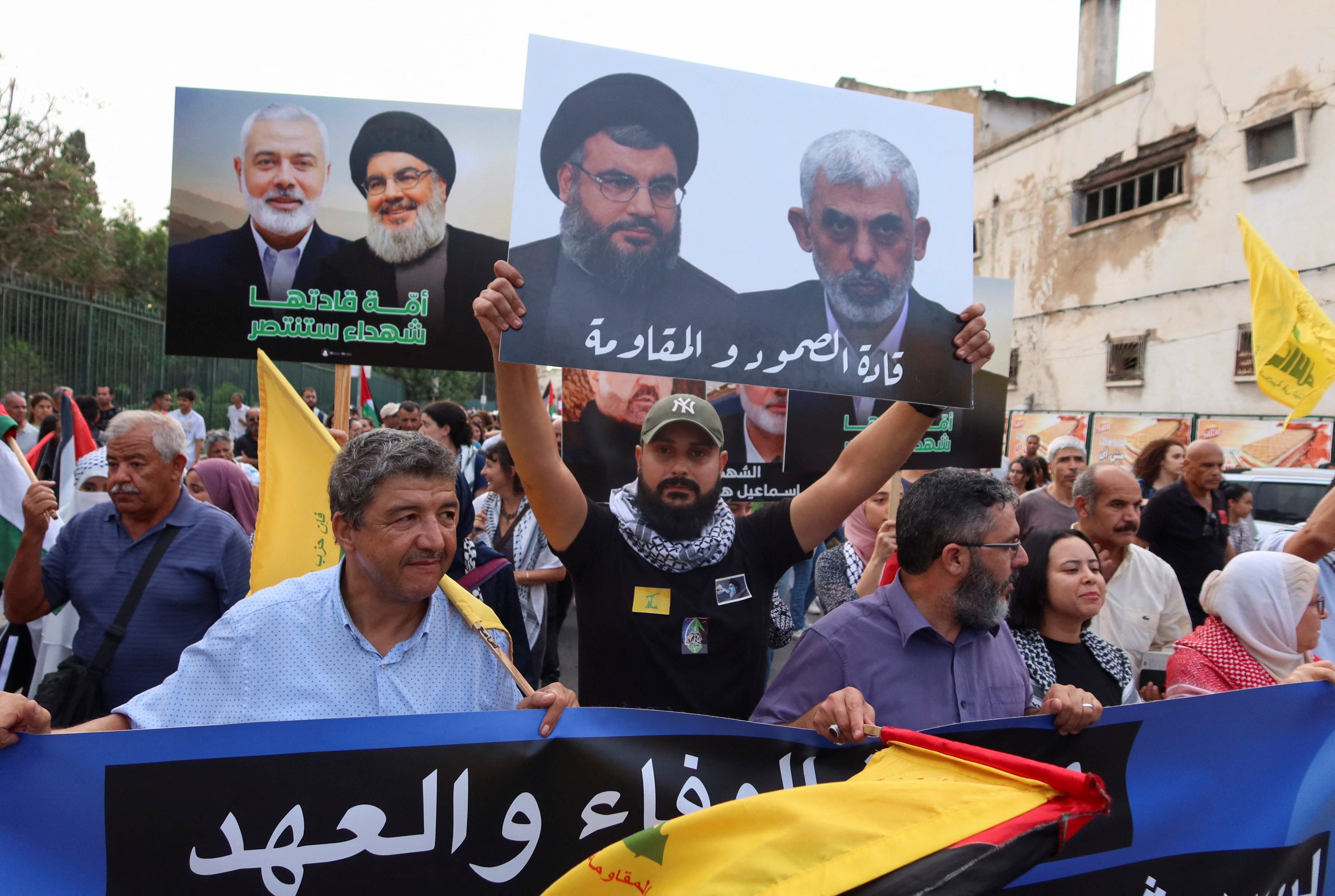Demonstrators carry pictures of late Hamas leader Ismail Haniyeh, left, late Hezbollah leader Sayyed Hassan Nasrallah, center, and Hamas leader Yahya Sinwar, during a protest in support of Lebanon and Gaza on the one-year anniversary of Hamas' Oct. 7 attack on Israel, in Tunis, Tunisia, on Oct. 7, 2024.