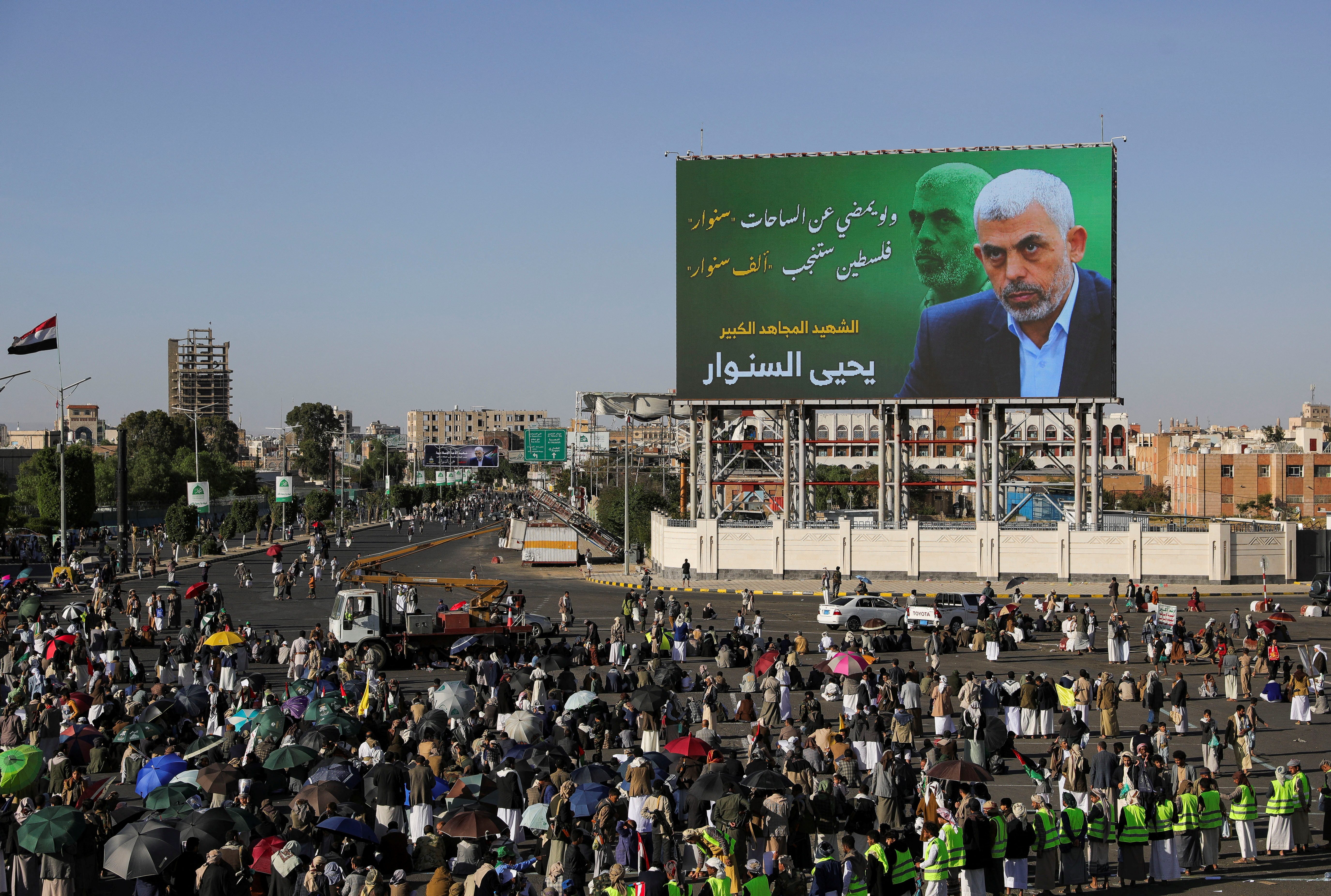 Protesters, mainly Houthi supporters, stand near a billboard showing the late Hamas leader Yahya Sinwar as they rally to show support to Lebanon's Hezbollah and Palestinians in the Gaza Strip, in Sanaa, Yemen October 18, 2024. REUTERS/Khaled Abdullah