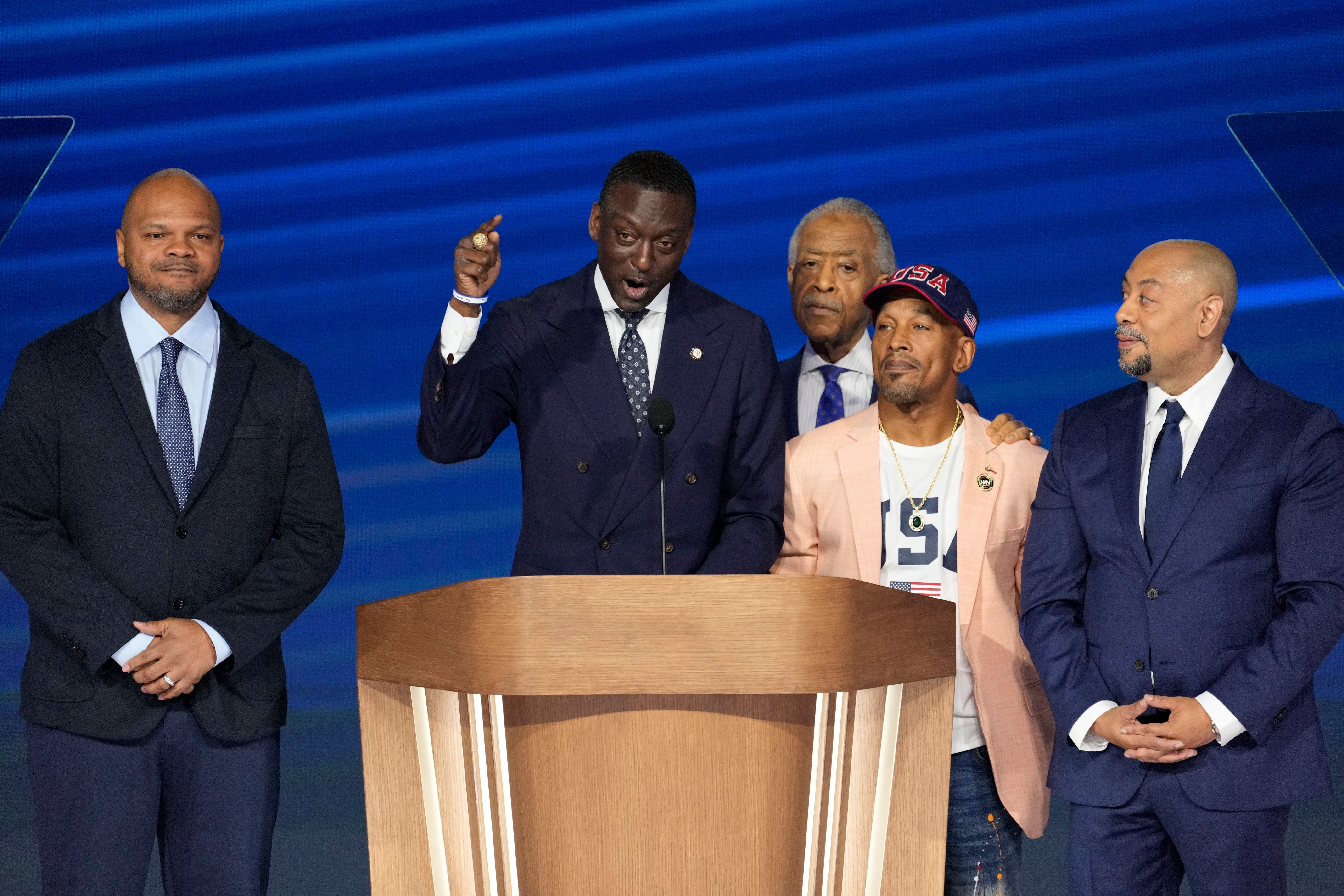 With the Rev. Al Sharpton behind them, members of the exonerated Central Park Five, from left, Kevin Richardson, Yusef Salaam, Korey Wise and Raymond Santana, address the Democratic National Convention in Chicago on Aug. 22, 2024.