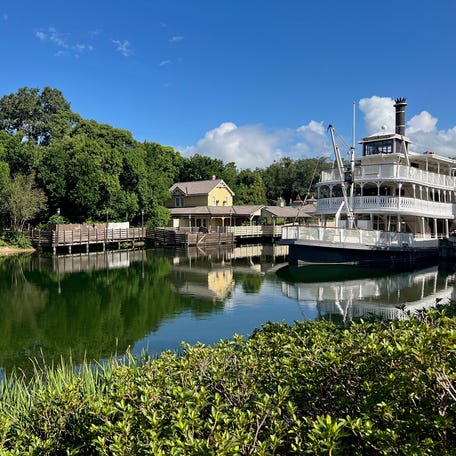 Liberty Square Riverboat takes guests along Rivers of America at Walt Disney World's Magic Kingdom. A separate raft transports guests to Tom Sawyer Island.