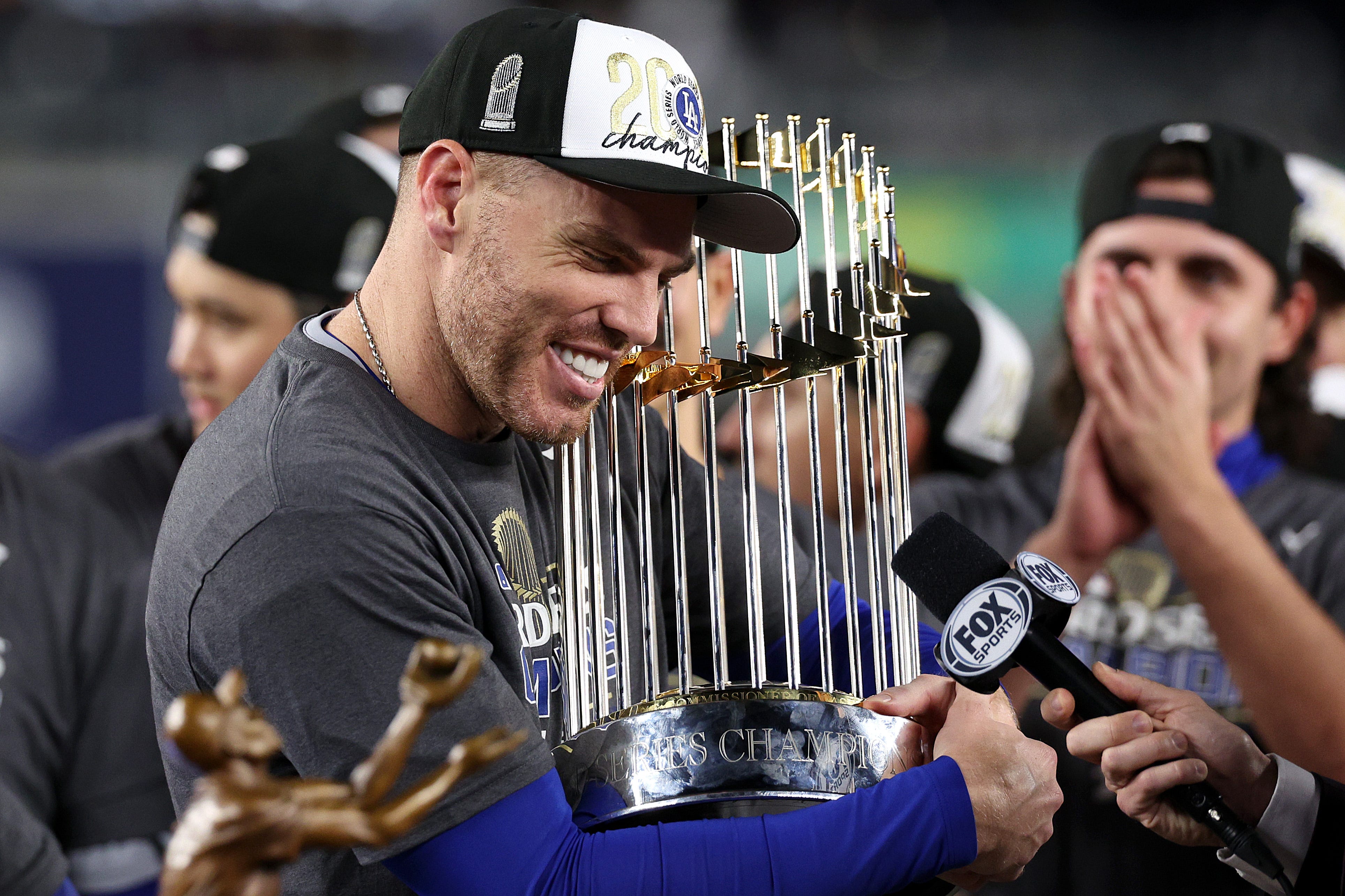 Freddie Freeman of the Dodgers celebrates with the Commissioner's Trophy after the Dodgers defeated the Yankees 7-6 in Game 5 to win the World Series.