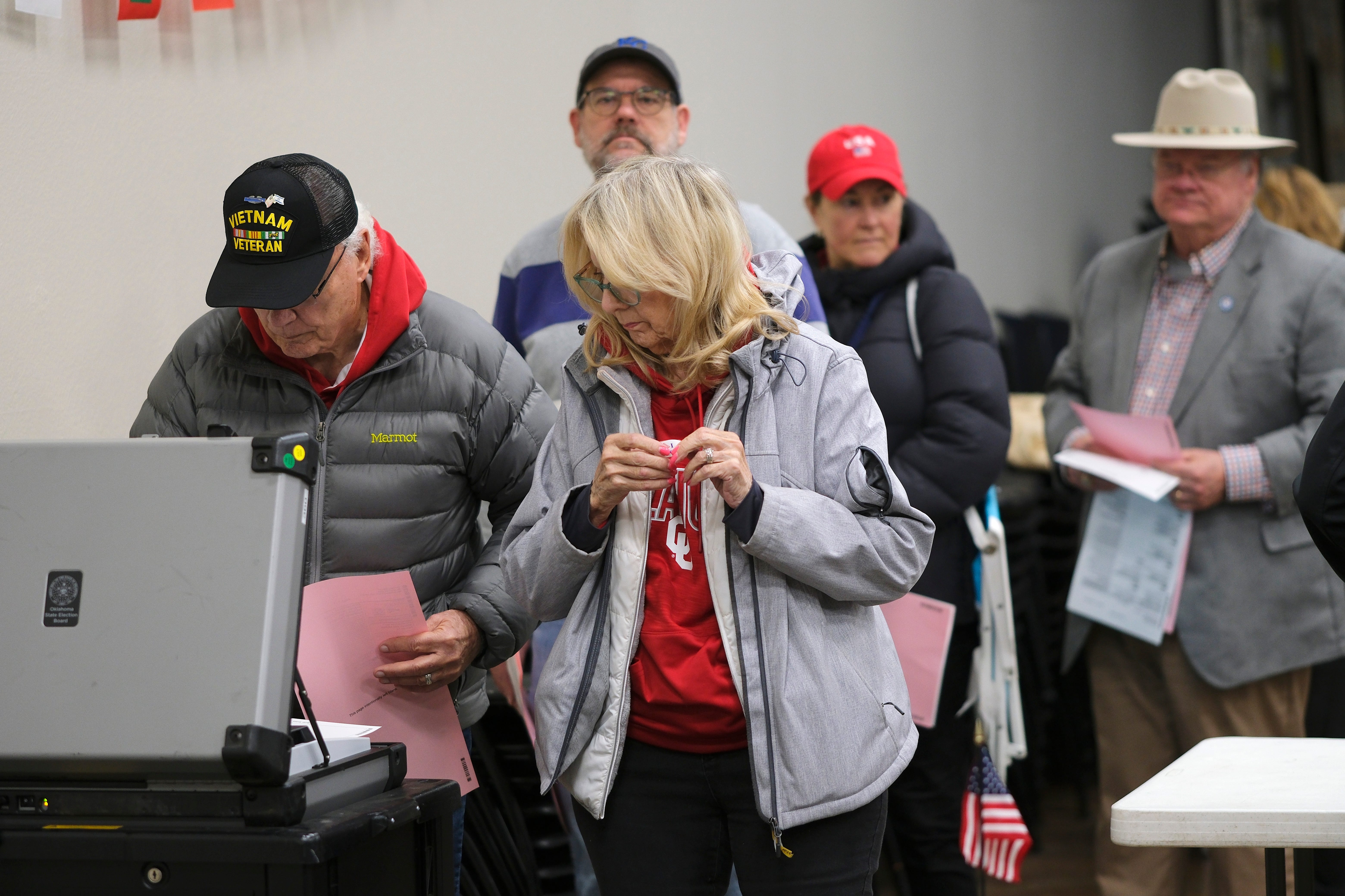 Voters wait in line to feed their ballots into the voting machines. Precinct 360 vote at Edmond Spring Creek Assembly of God during early morning voting on Nov. 5, 2024.