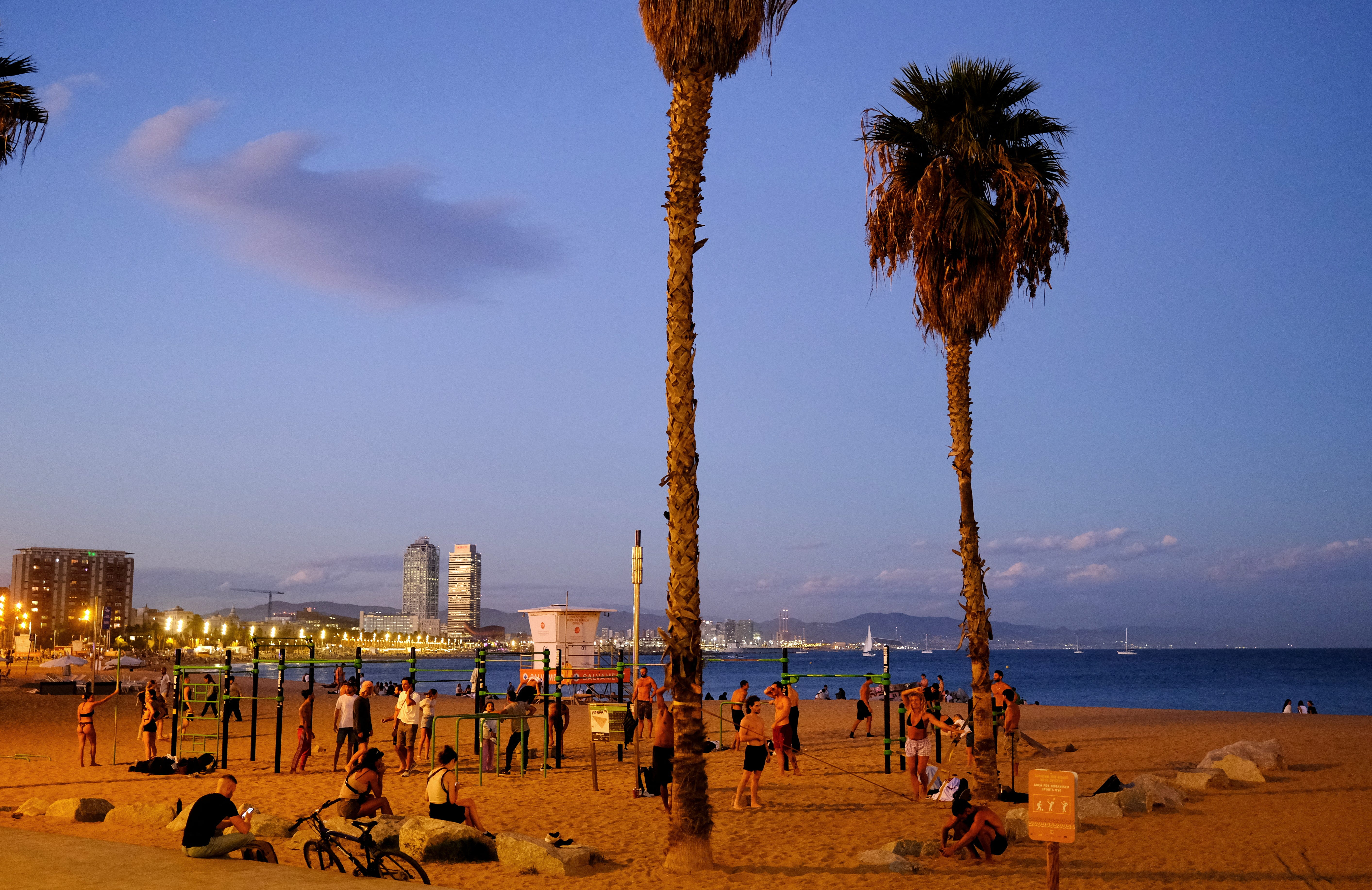 Tourists and locals enjoy the Barceloneta beach in the sunset during the autumn weather in Barcelona, Spain on September 26, 2024.