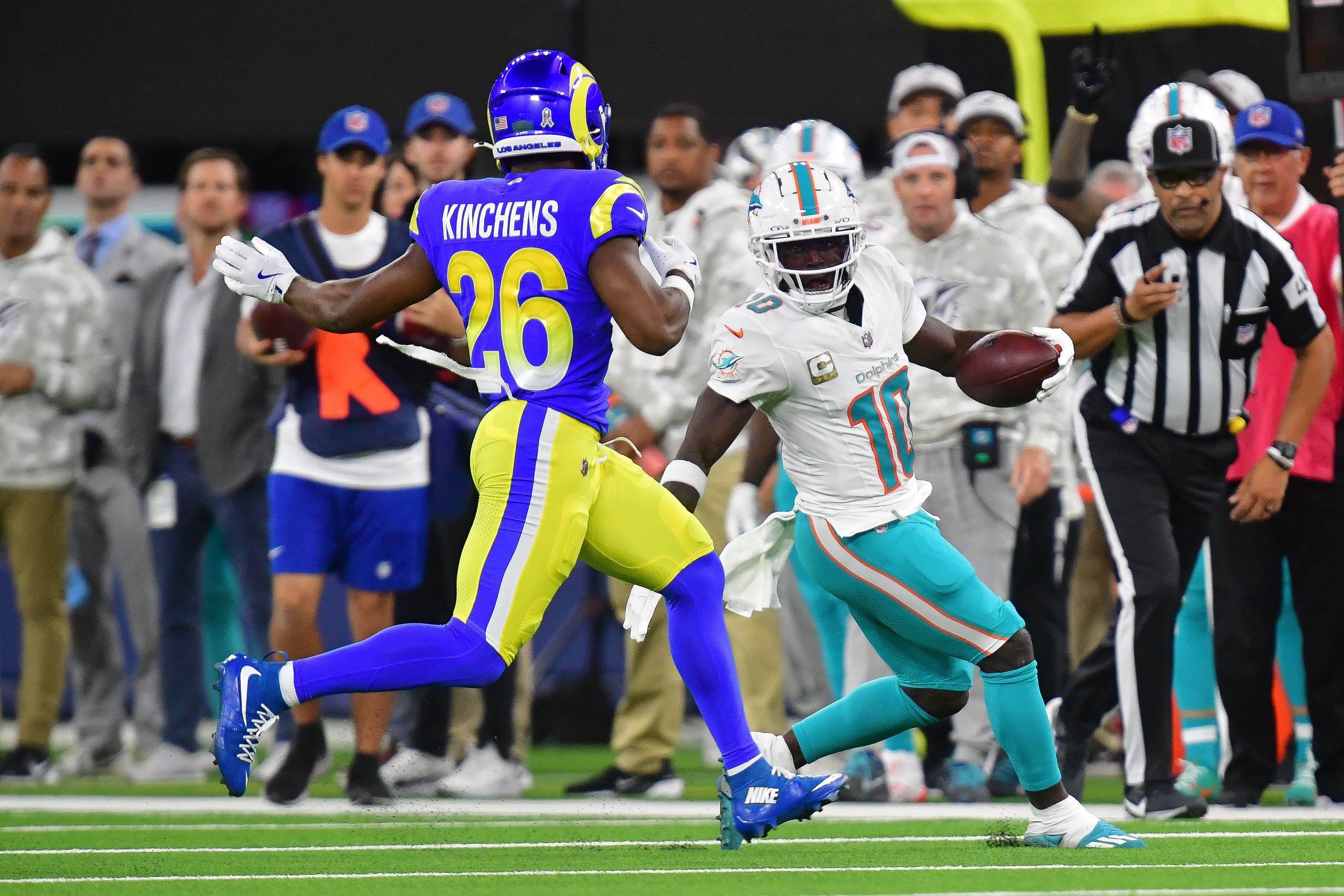 Nov 11, 2024; Inglewood, California, USA; Miami Dolphins wide receiver Tyreek Hill (10) runs the ball against Los Angeles Rams safety Kamren Kinchens (26) during the first half at SoFi Stadium. Mandatory Credit: Gary A. Vasquez-Imagn Images