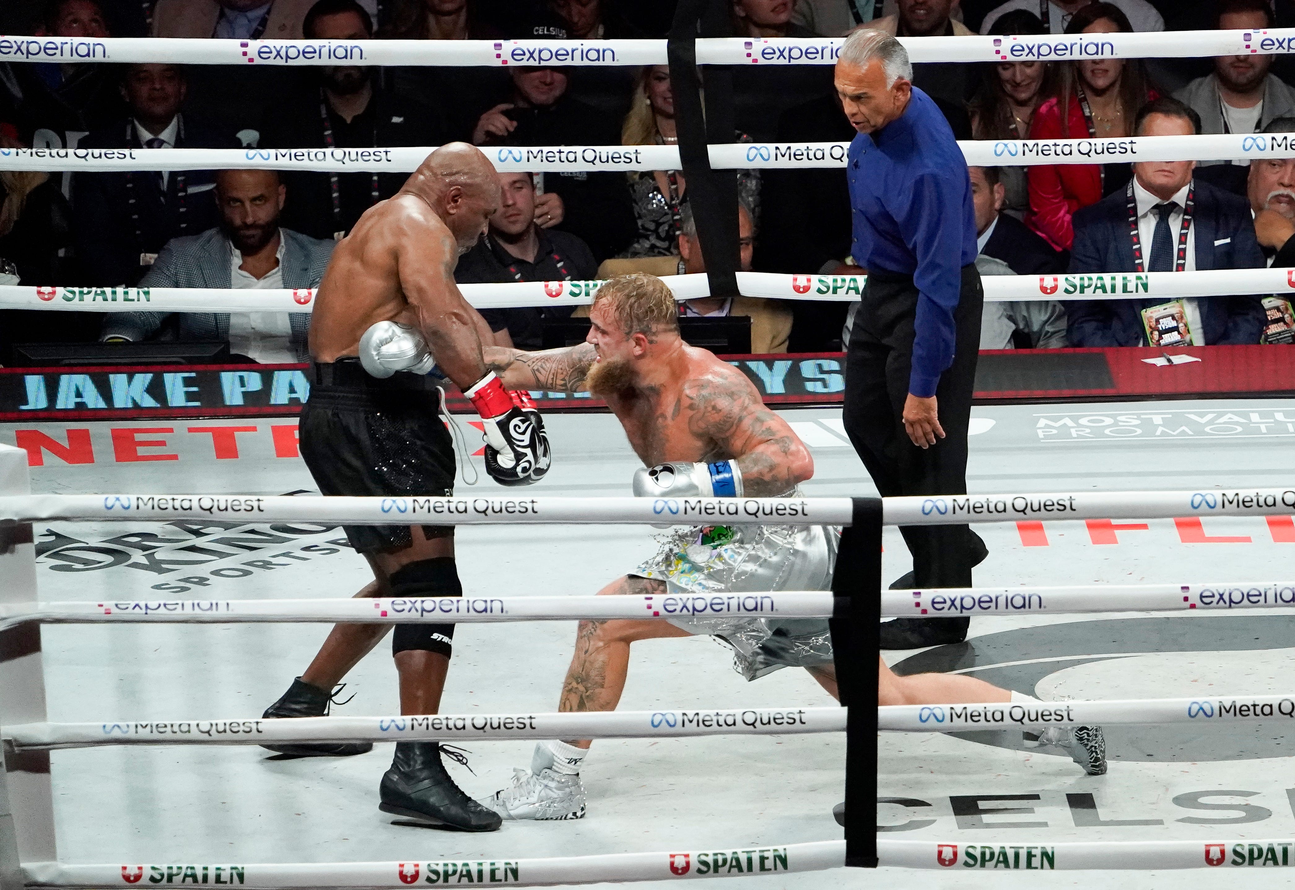 Mike Tyson, left, takes a punch from Jake Paul during their heavyweight boxing fight at AT&T Stadium in Arlington, Texas on Nov. 15, 2024.