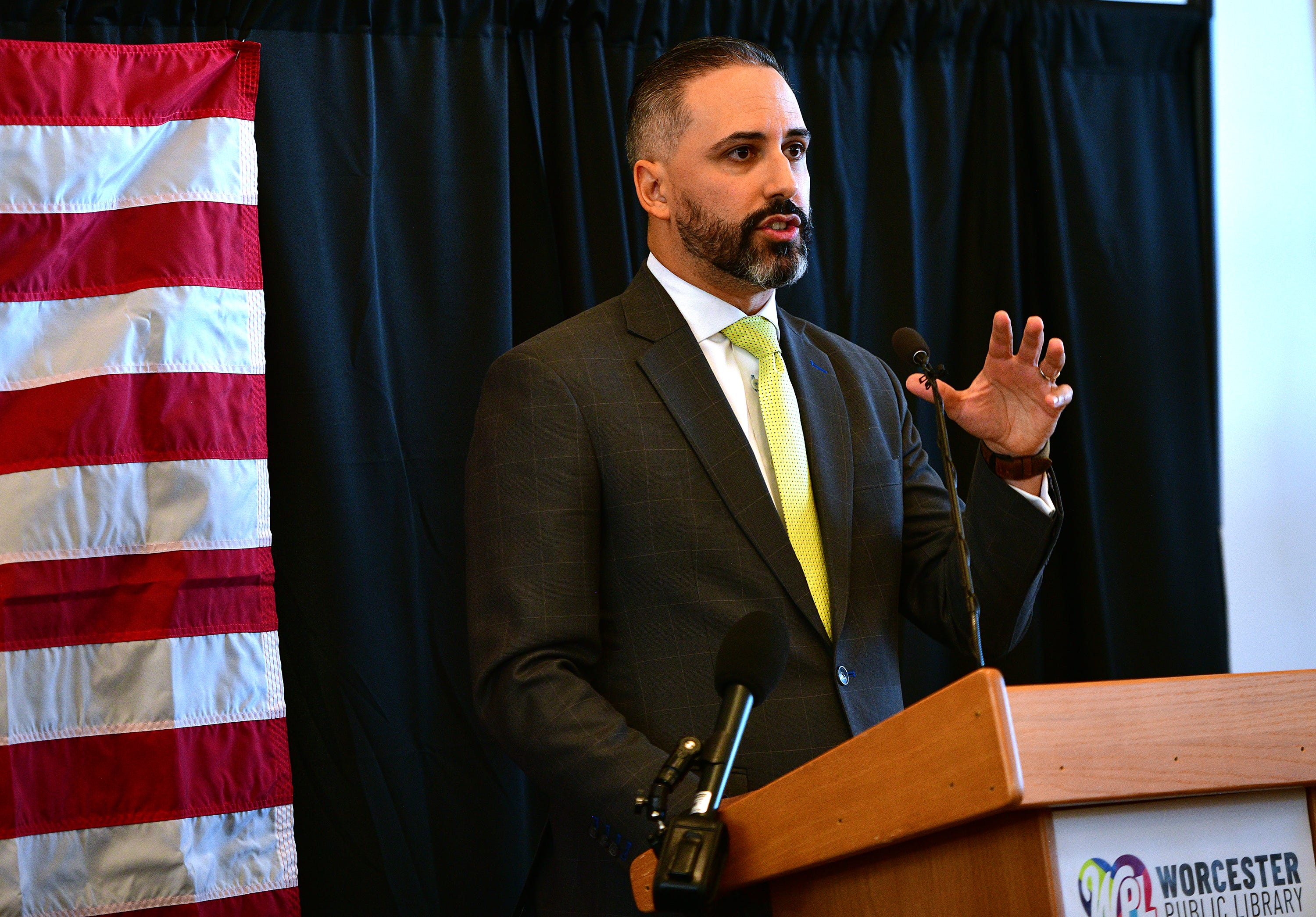 City Manager Eric Batits gives welcoming remarks as seventy-six new United States citizens prepare to take the Oath of Allegiance at the Worcester Public Library during a ceremony held by the U.S. Citizenship and Immigration Services on Tuesday.