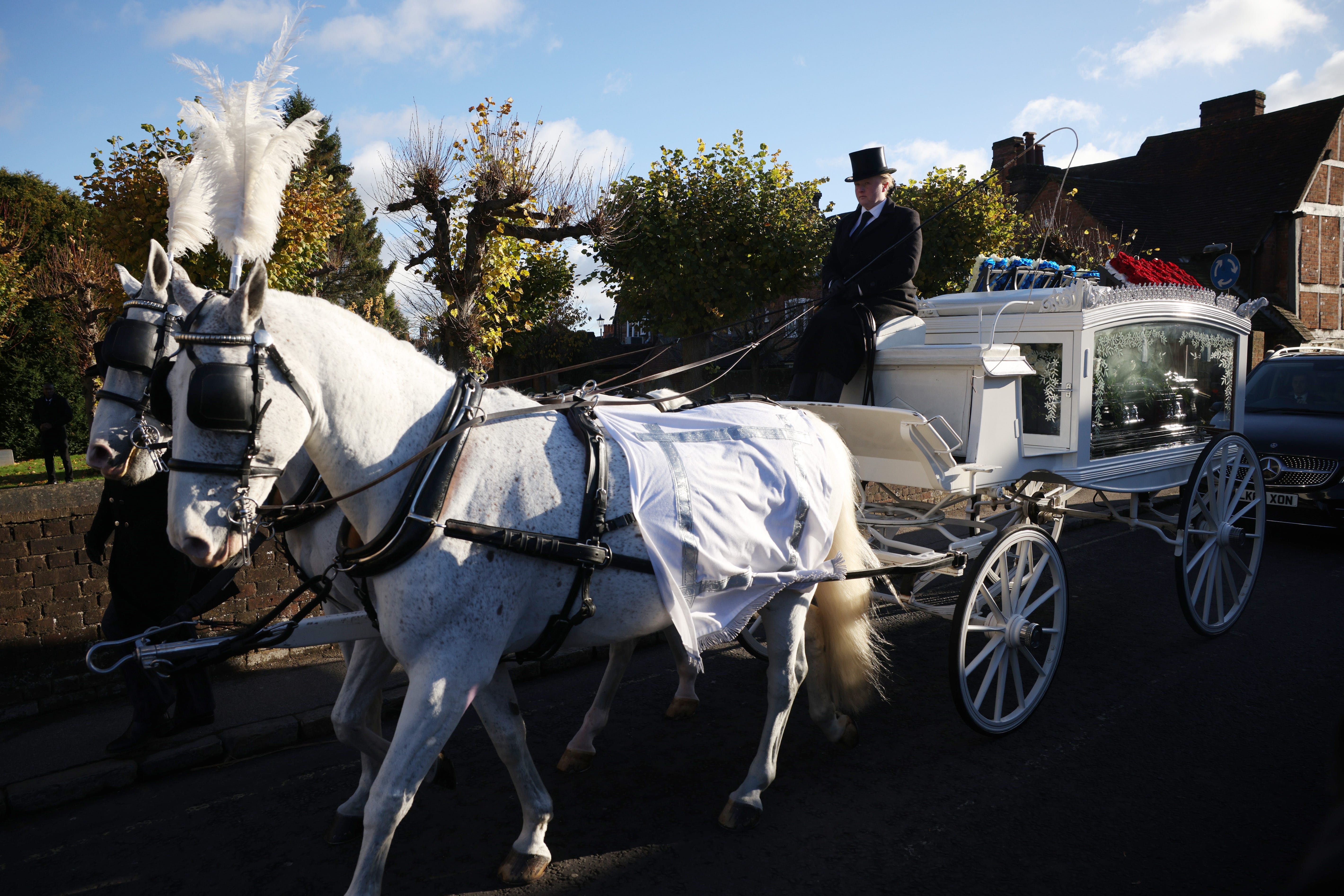 AMERSHAM, ENGLAND - NOVEMBER 20: A white horse drawn hearse arrives for the funeral of singer Liam Payne, former member of One Direction on November 20, 2024 in Amersham, United Kingdom. Former One Direction star Liam Payne's private funeral in Amersham has been widely anticipated to draw celebrities and fans alike, wishing to pay their final respects. The singer died after falling from a hotel balcony in Buenos Aires on October 16. (Photo by Dan Kitwood/Getty Images)