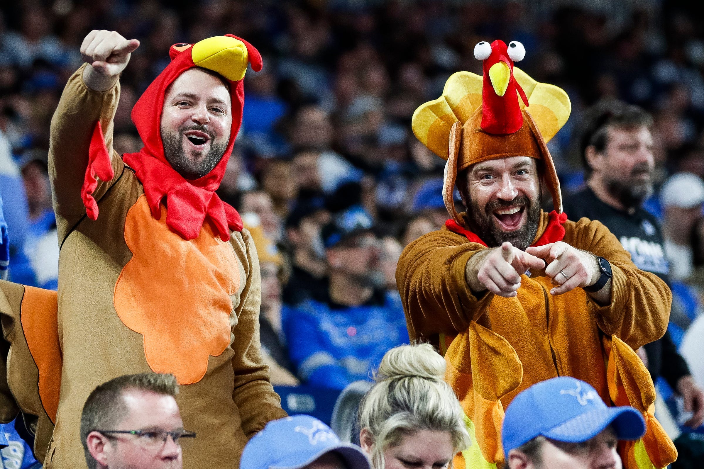 Detroit Lions fans wear turkey outfits during the Thanksgiving Day game against the Green Bay Packers at Ford Field in Detroit on Nov. 23, 2023.