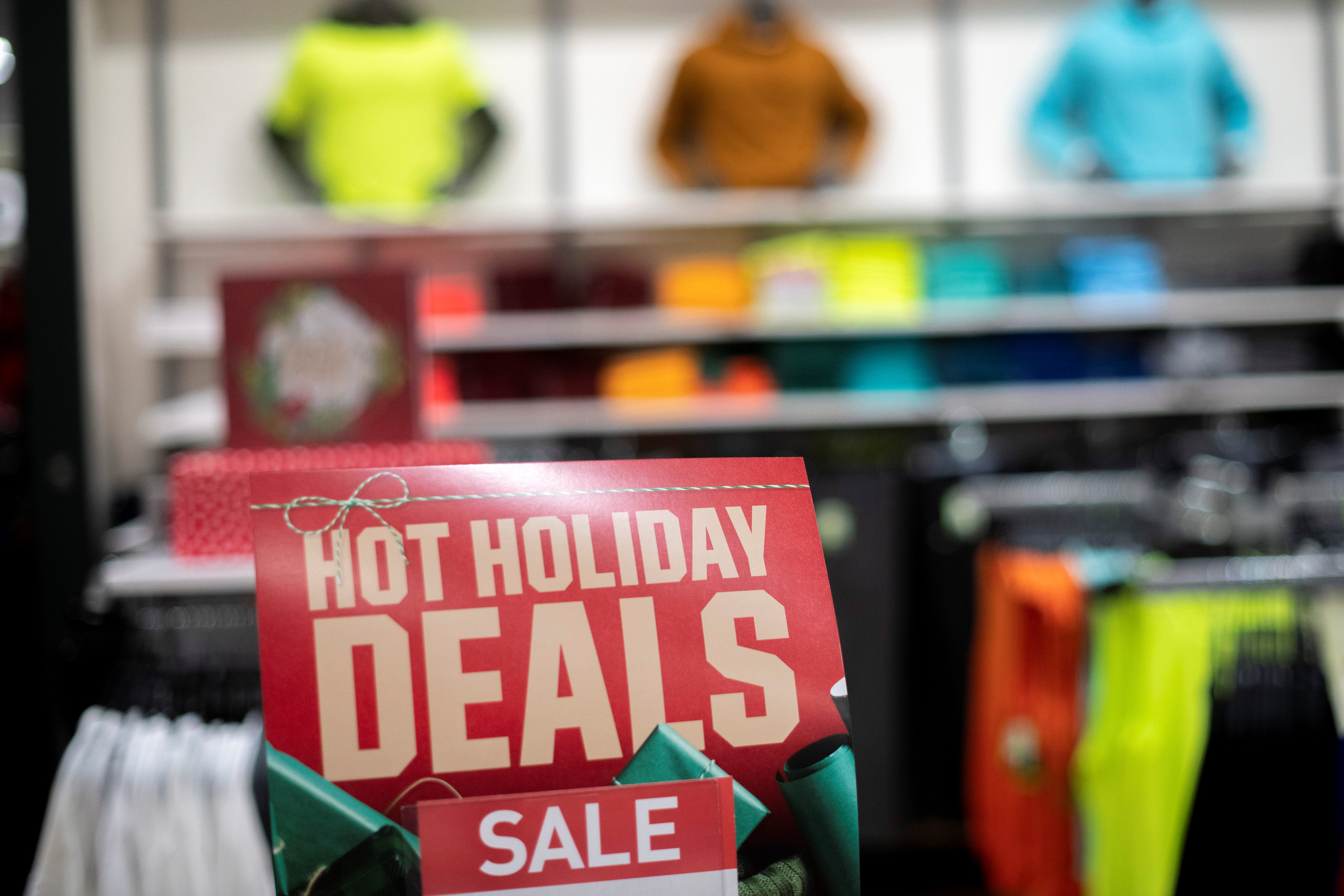 Athletic wear is displayed for sale beside a sign stating "HOT HOLIDAY DEALS SALE" at a Dick's Sporting Goods store in Collegeville, Pennsylvania U.S. November 20, 2020.
