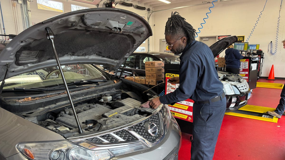 Toby Jackson, a certified technician at Take 5 Oil Change in Norwich, checks a car's oil.