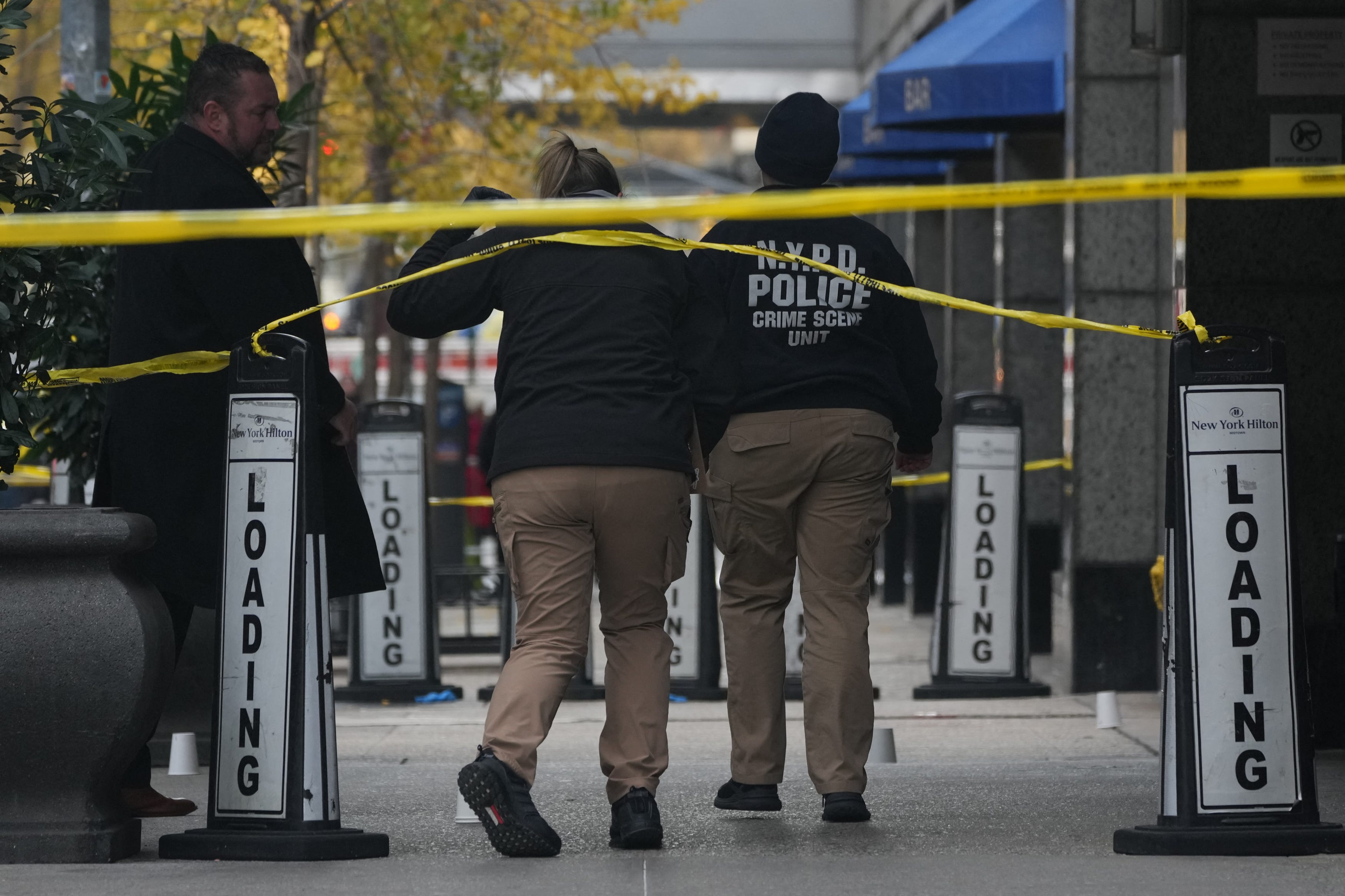 Police cover evidence with paper cups at the scene where UnitedHealthcare CEO Brian Thompson was reportedly shot on Dec. 4, 2024 in New York.