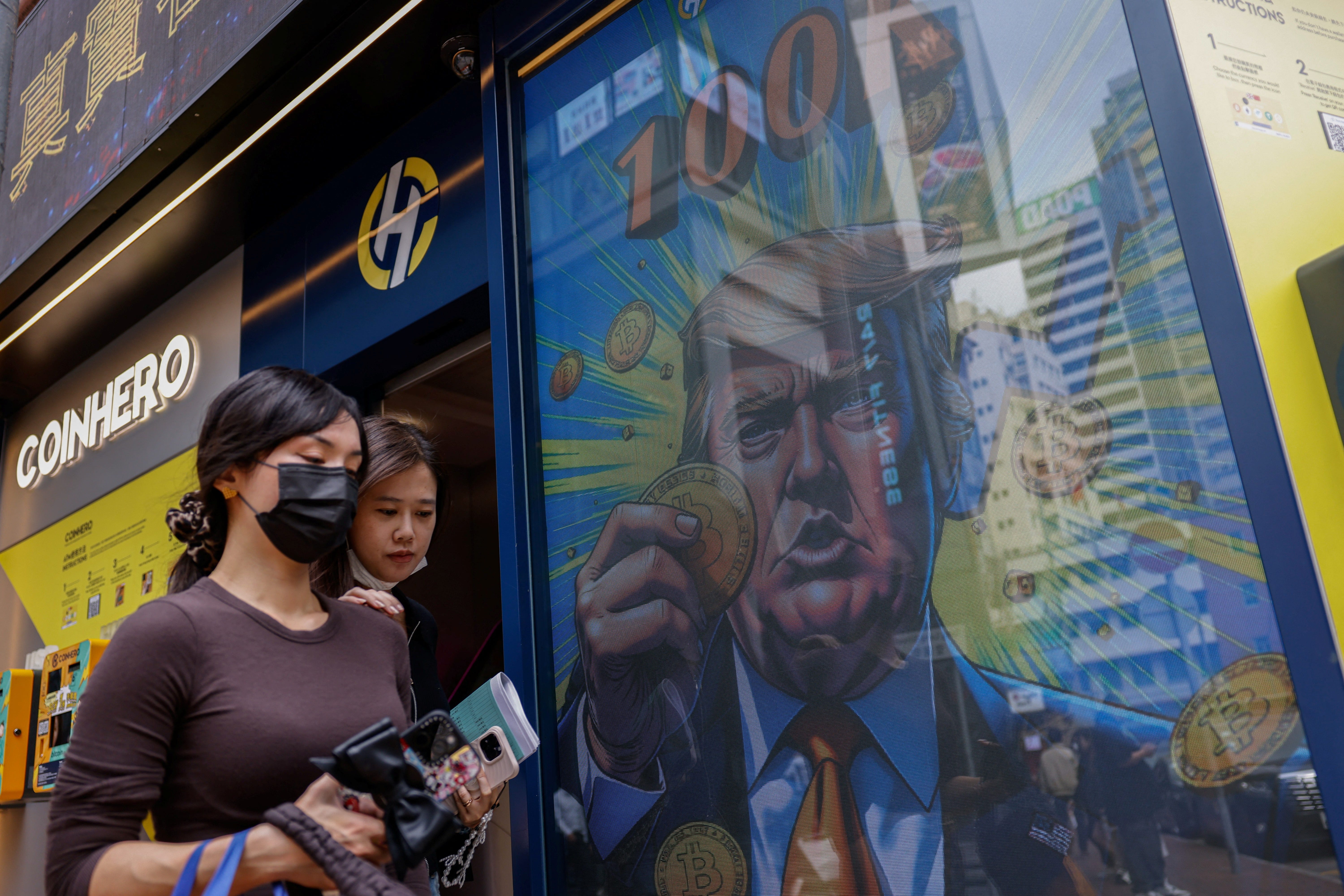 An illustration featuring President-elect Donald Trump holding bitcoin is displayed outside a cryptocurrency exchange store in Hong Kong, China, on Dec. 5, 2024.