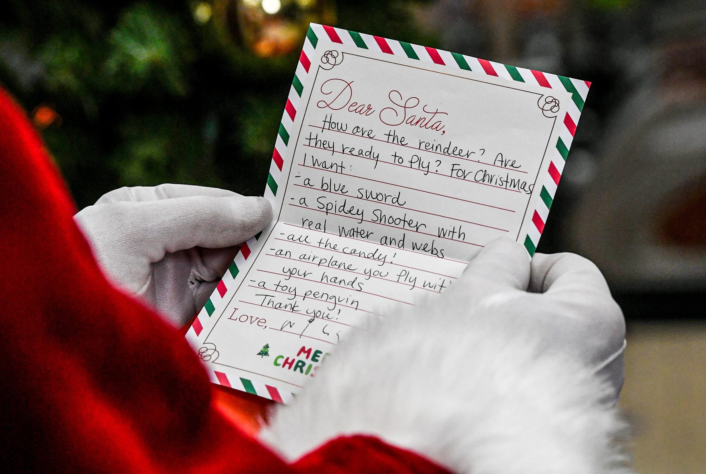 Santa Claus reads a letter at his photo session area at the Anderson Mall before children and families visit him in Anderson, S.C. Friday, December 22, 2023.