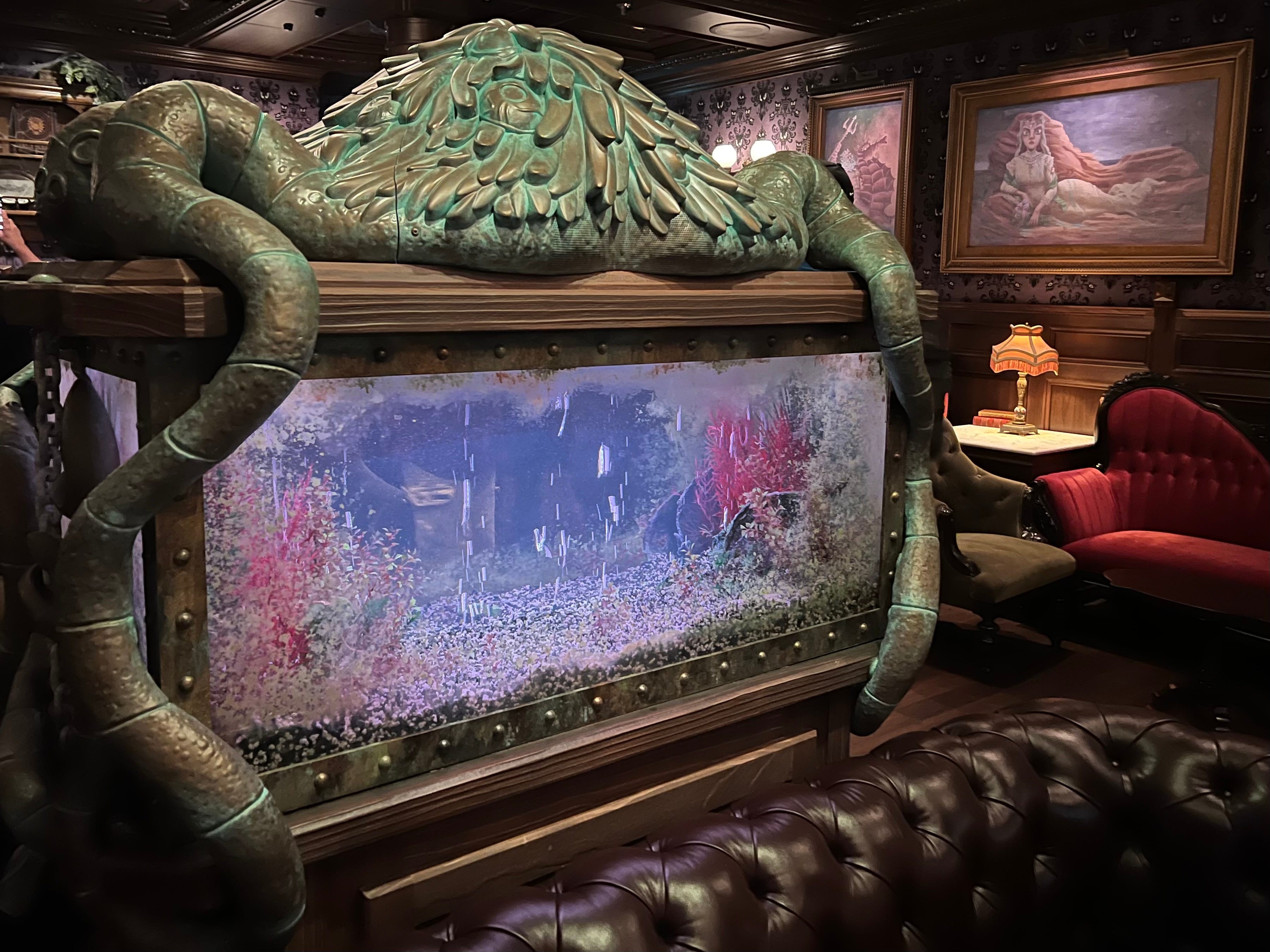 At times, ghostly fish appear in an ornate fish tank in the middle of Haunted Mansion Parlor.