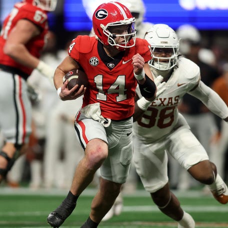 Georgia quarterback Gunner Stockton (14) runs with the ball against Texas during the second half in the 2024 SEC championship game at Mercedes-Benz Stadium.