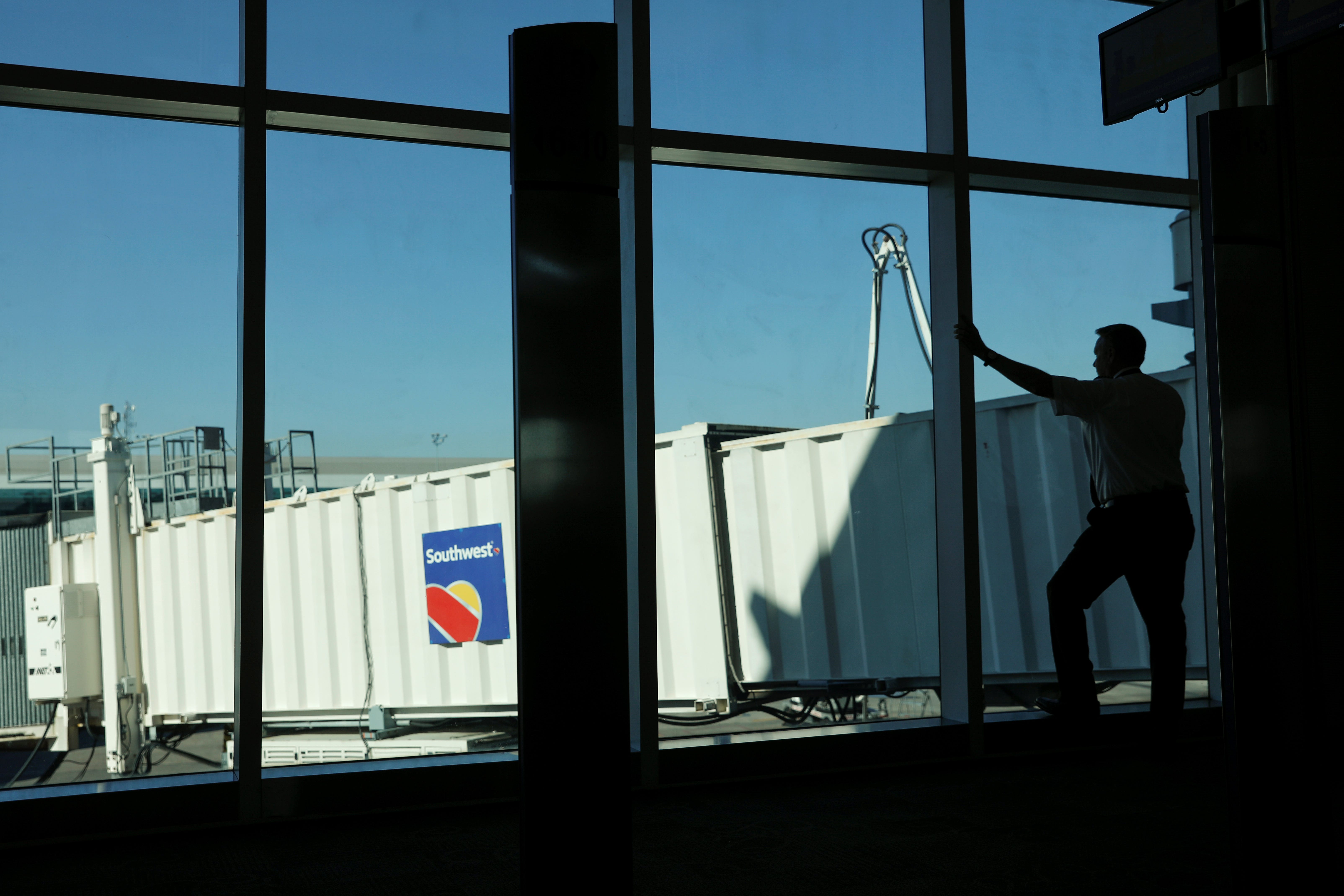 A Southwest pilot talks on his phone as he waits for a plane to arrive at William P. Hobby Airport in Houston, Texas, February 20, 2019. REUTERS/Mike Blake