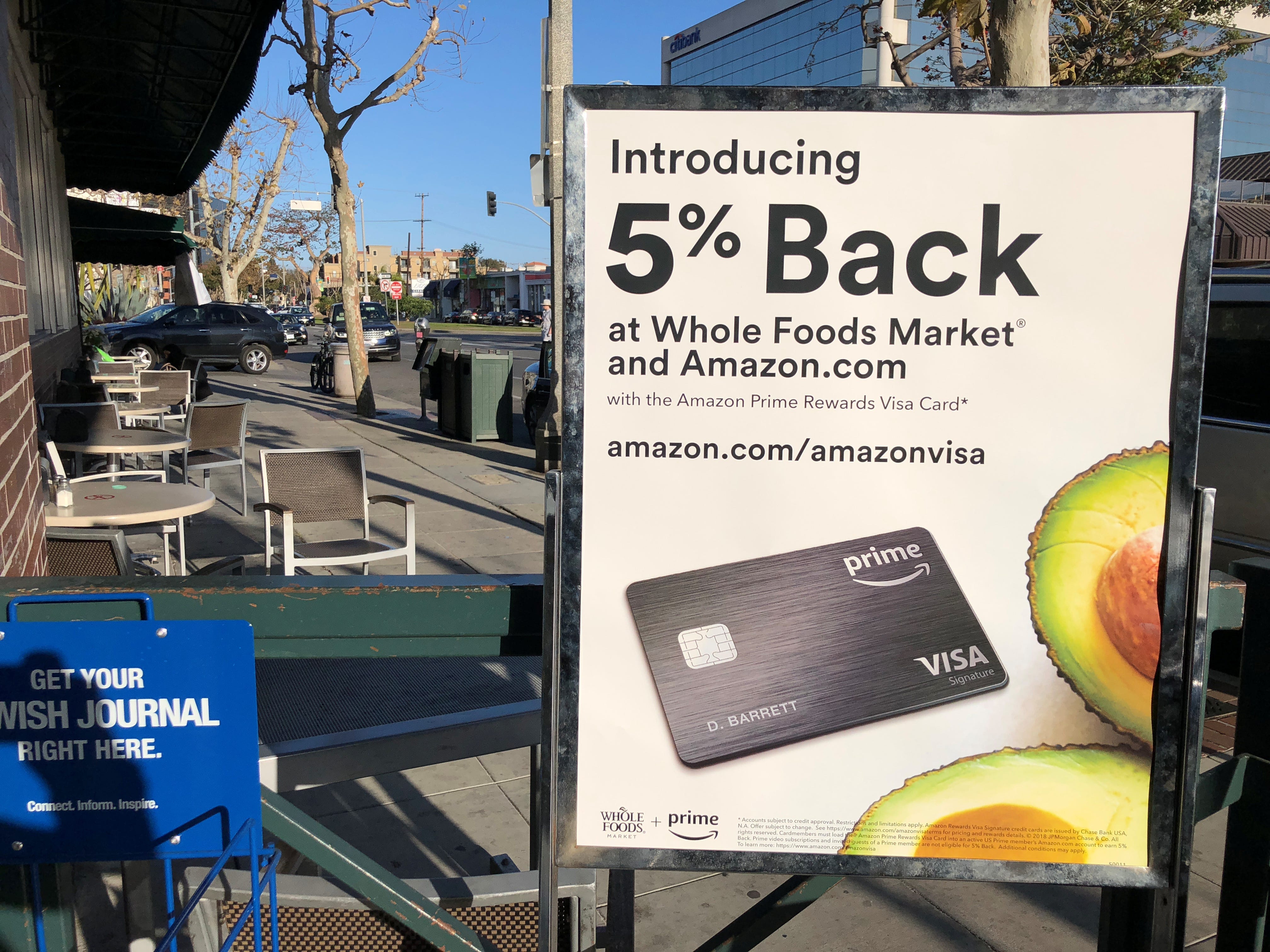 A sign advertising a credit card offering a discount at Whole Foods and Amazon is seen outside a Whole Foods store in Los Angeles, California, U.S., February 26, 2018. Picture taken February 26, 2018. REUTERS/Lucy Nicholson