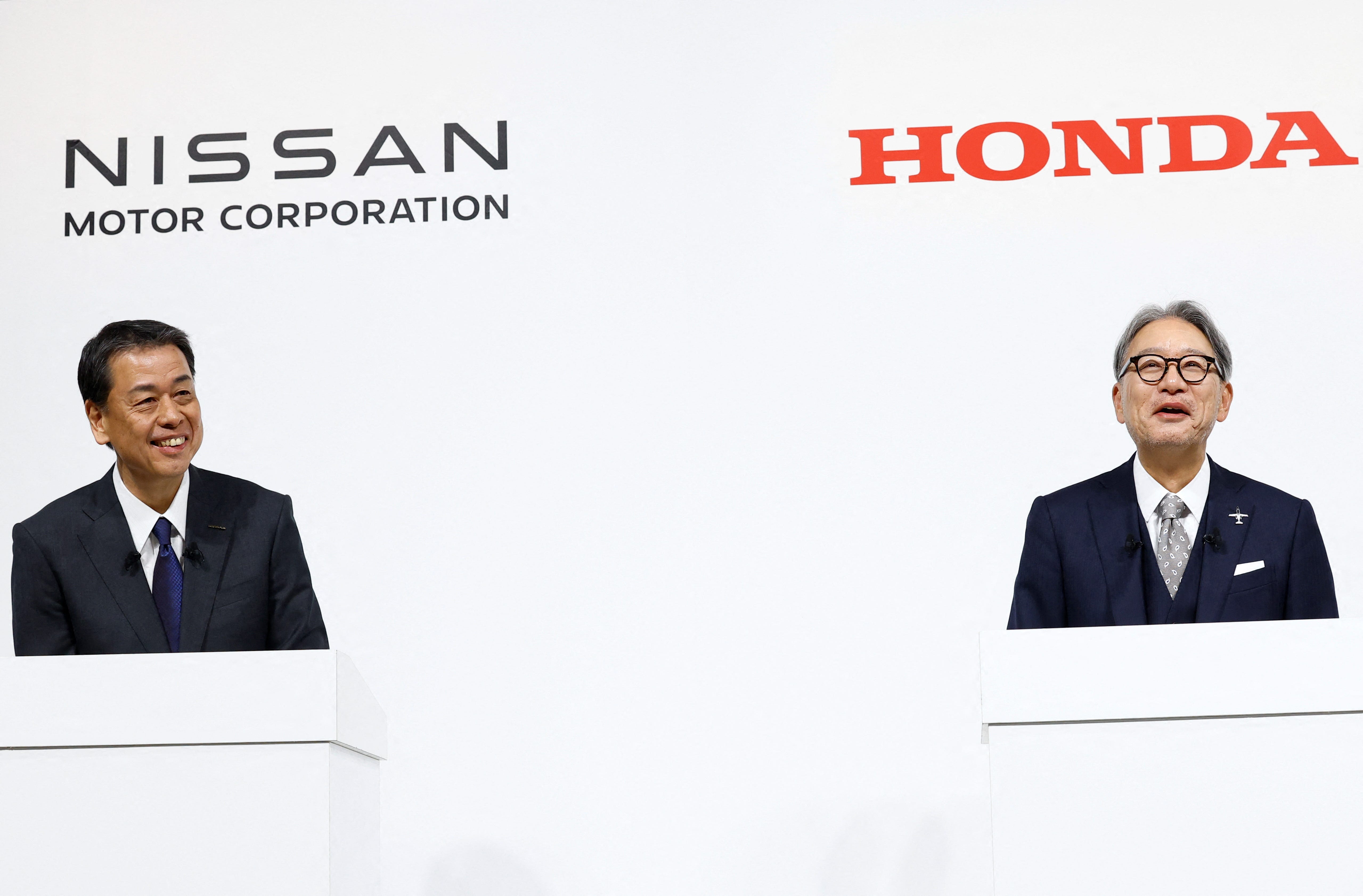 Makoto Uchida, Director, Representative Executive Officer, President and CEO of Nissan Motor Corporation, and Toshihiro Mibe, Director, President and Representative Executive Officer of Honda, react during a joint press conference on their merger talks, in Tokyo, Japan, December 23, 2024.