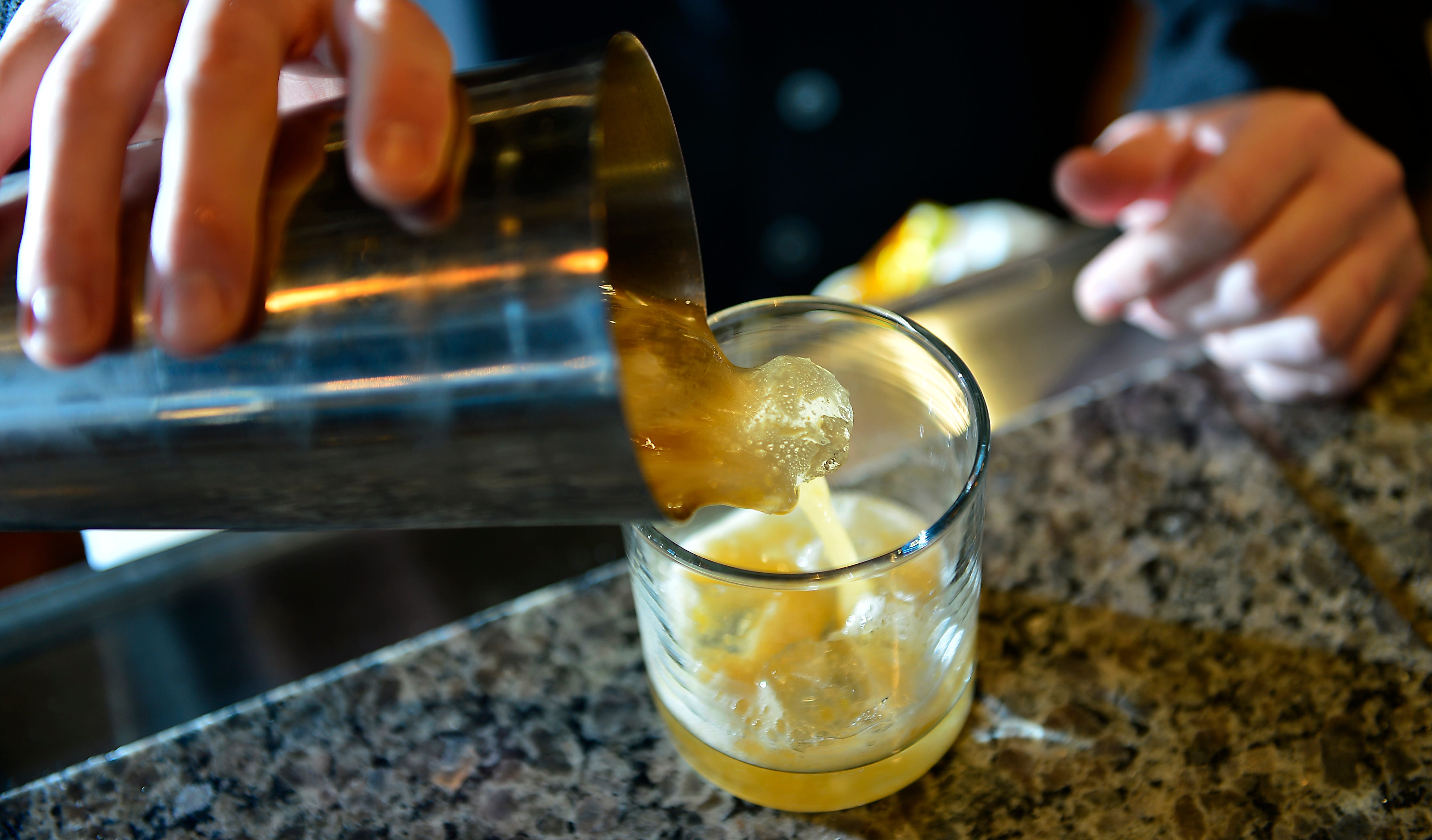Bartender Jesse Meredith of the Cribbs Kitchen in downtown Spartanburg, South Carolina shows how to make a mocktail on Feb. 4, 2022. This is the Sweet as Peaches mocktails which is white tea, lemon juice, peach puree and simple syrup.