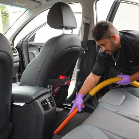 Arturo Villanueva, 37, washes and vacuums a car in Oxnard, California on Feb. 20, 2024.
