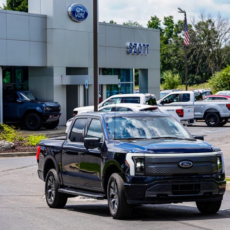 Woody Gontina, 49, Royal Oak, takes delivery of his new Ford F-150 Lightning that he purchased from New Car Salesman Liam Belill, 28, of Flushing, Mich. at Szott Ford dealership in Holly, Mich. on Thursday, Aug. 8, 2024.
