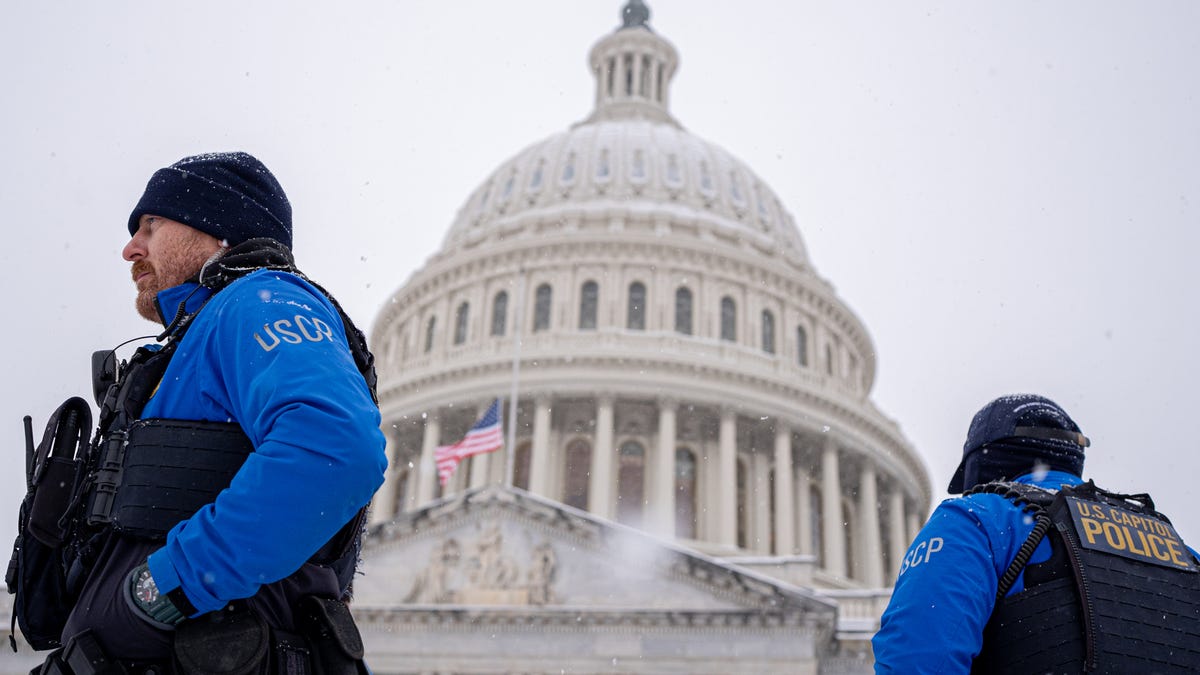 The Dome of the U.S. Capitol is visible as officers stand guard in a winter storm on Jan. 6, 2025 in Washington, DC. Congress is scheduled to certify the 2024 presidential election on Monday, four years after a mob of supporters of then-President Donald Trump rioted.
