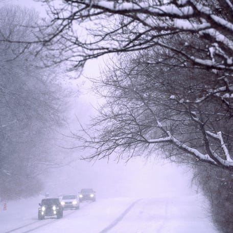 Cars move along Meridian St. during the first major snow of 2025, Monday in Indianapolis.