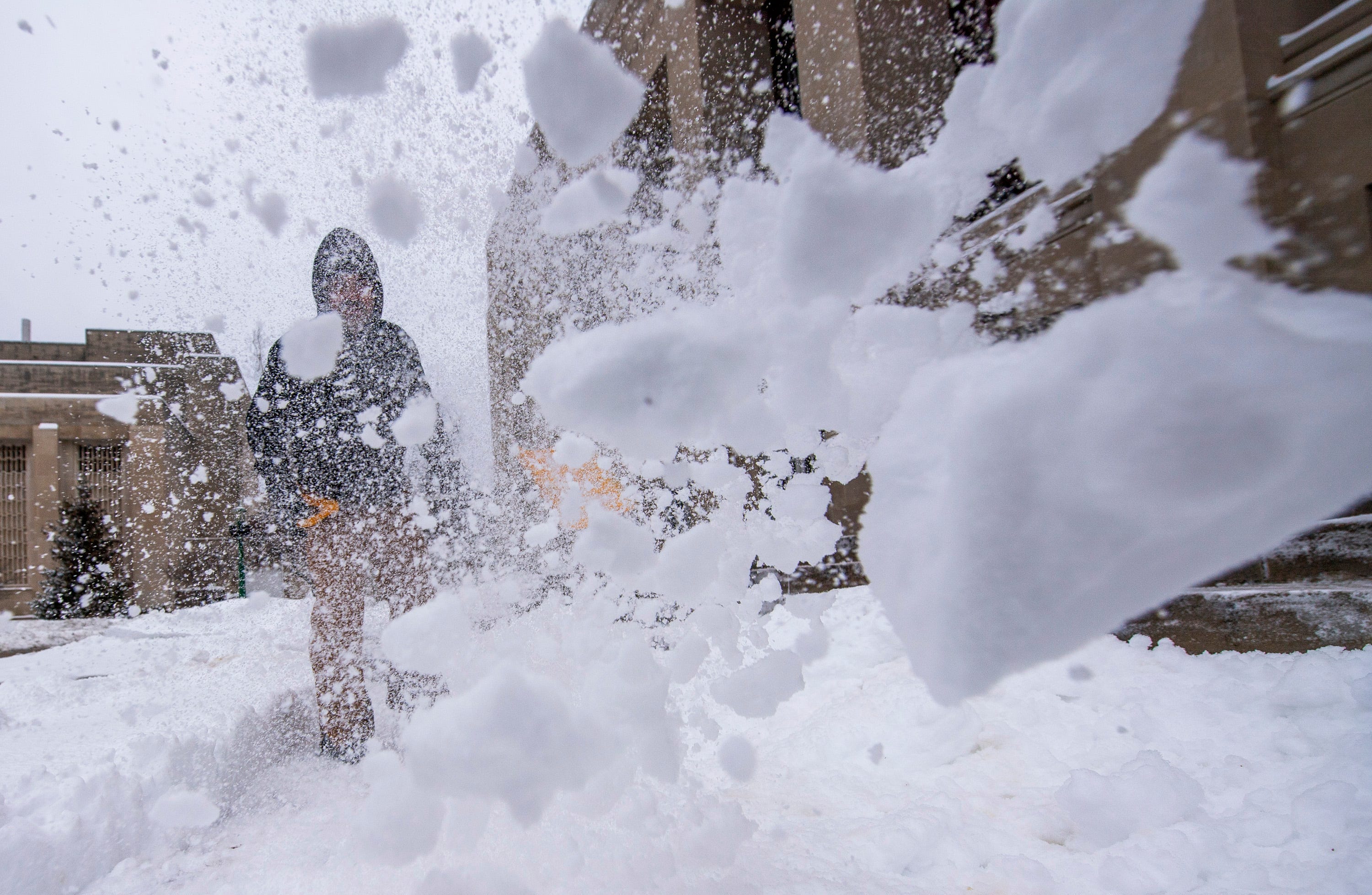 Ben Minnick shovels the sidewalks in front of the Indiana University auditorium on Jan. 7, 2025.
