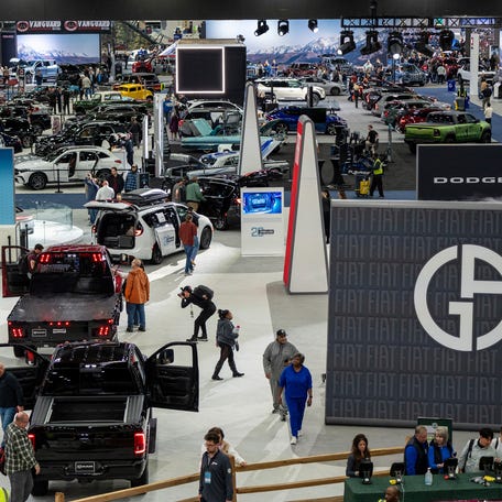 People walk alongside various vehicles during the 2025 Detroit Auto Show inside the Huntington Place in Detroit on Saturday, Jan. 11, 2025.