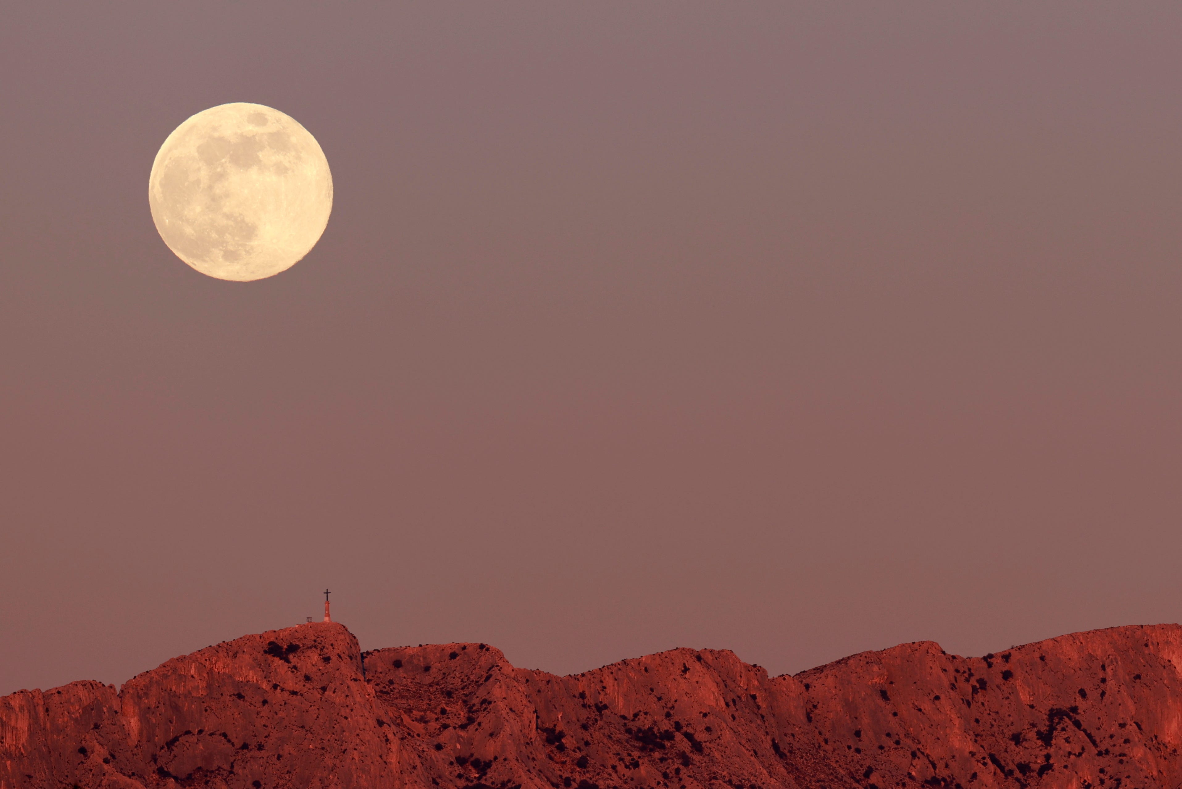 The full moon is pictured above the Montagne Sainte-Victoire, a limestone mountain ridge in the south of France, January 13, 2025.