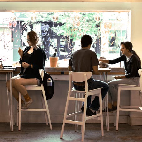 Customers enjoy their coffee and do remote work at the front window of Vagabond Coffee Co. on Wednesday morning.