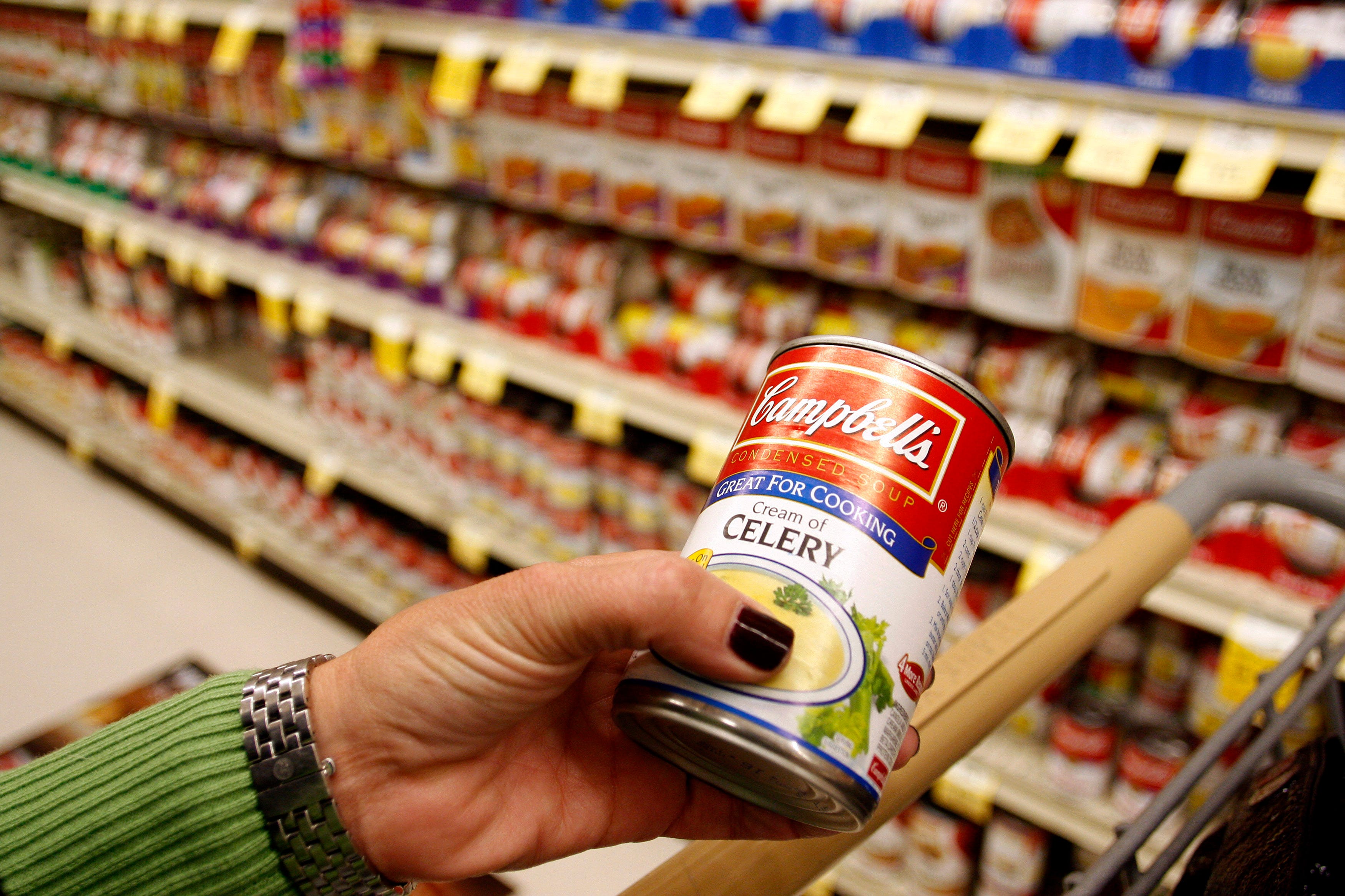 A customer holds a can of cream of celery Campbell's Soup at a grocery store in Phoenix, Arizona. Inflation has remained stubbornly high in recent months.