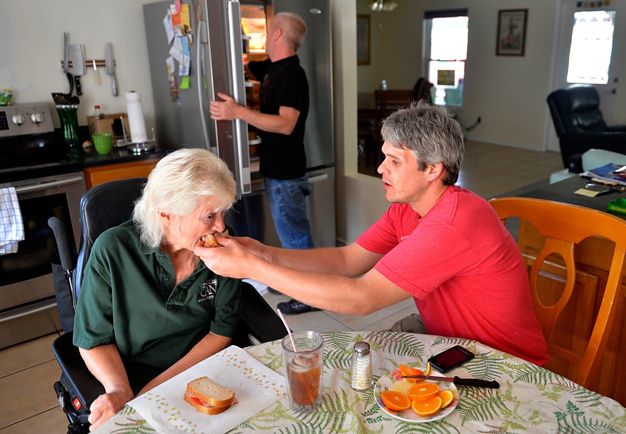 Cathy Jordan, 62, of Parrish, FL, is fed by her caregiver, Adam Burnett.
