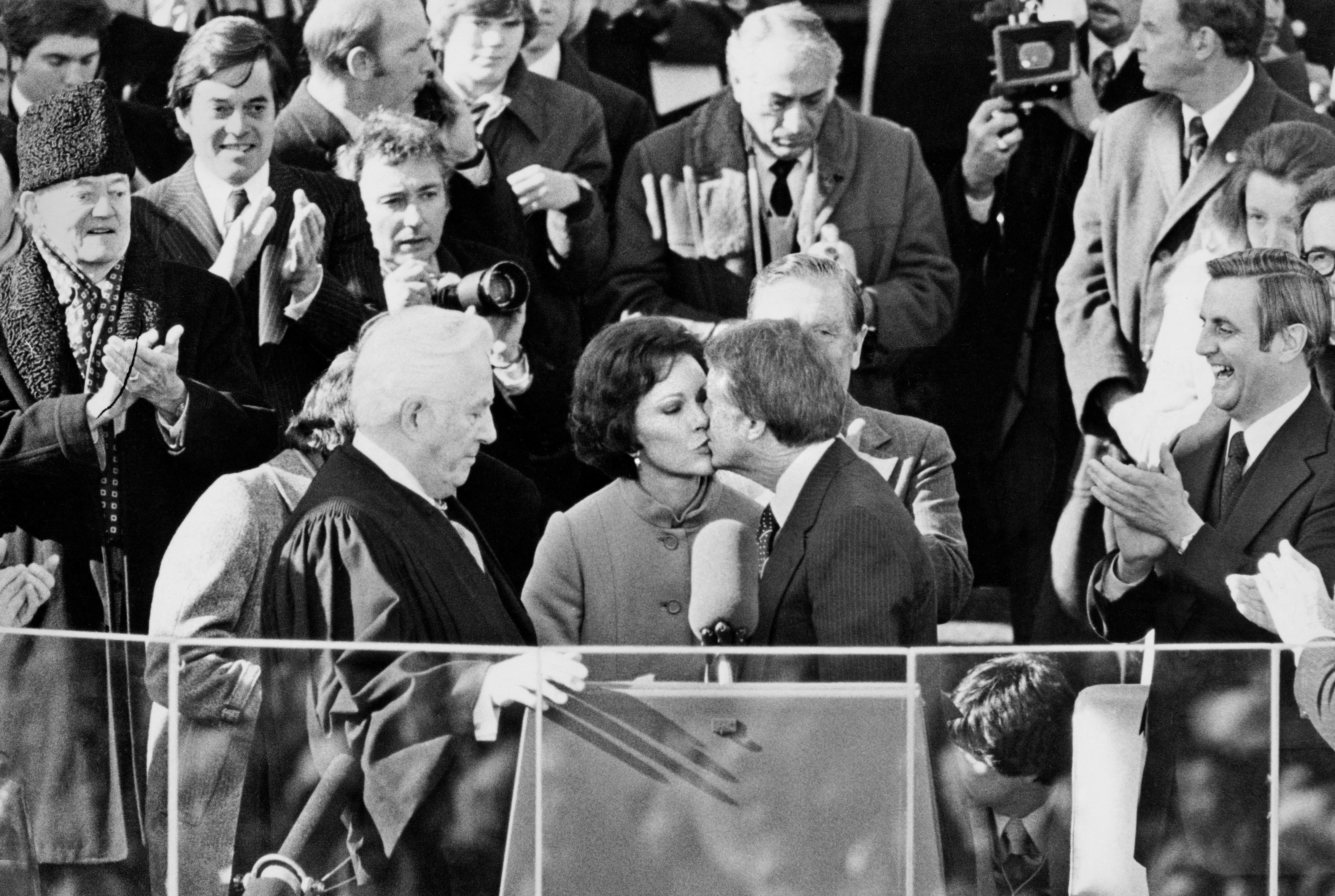 Rosalynn Carter gives her husband, the new President of the United States Jimmy Carter, a congratulatory kiss after he took the oath of office on the steps of the Capitol in Washington on January 20, 1977.