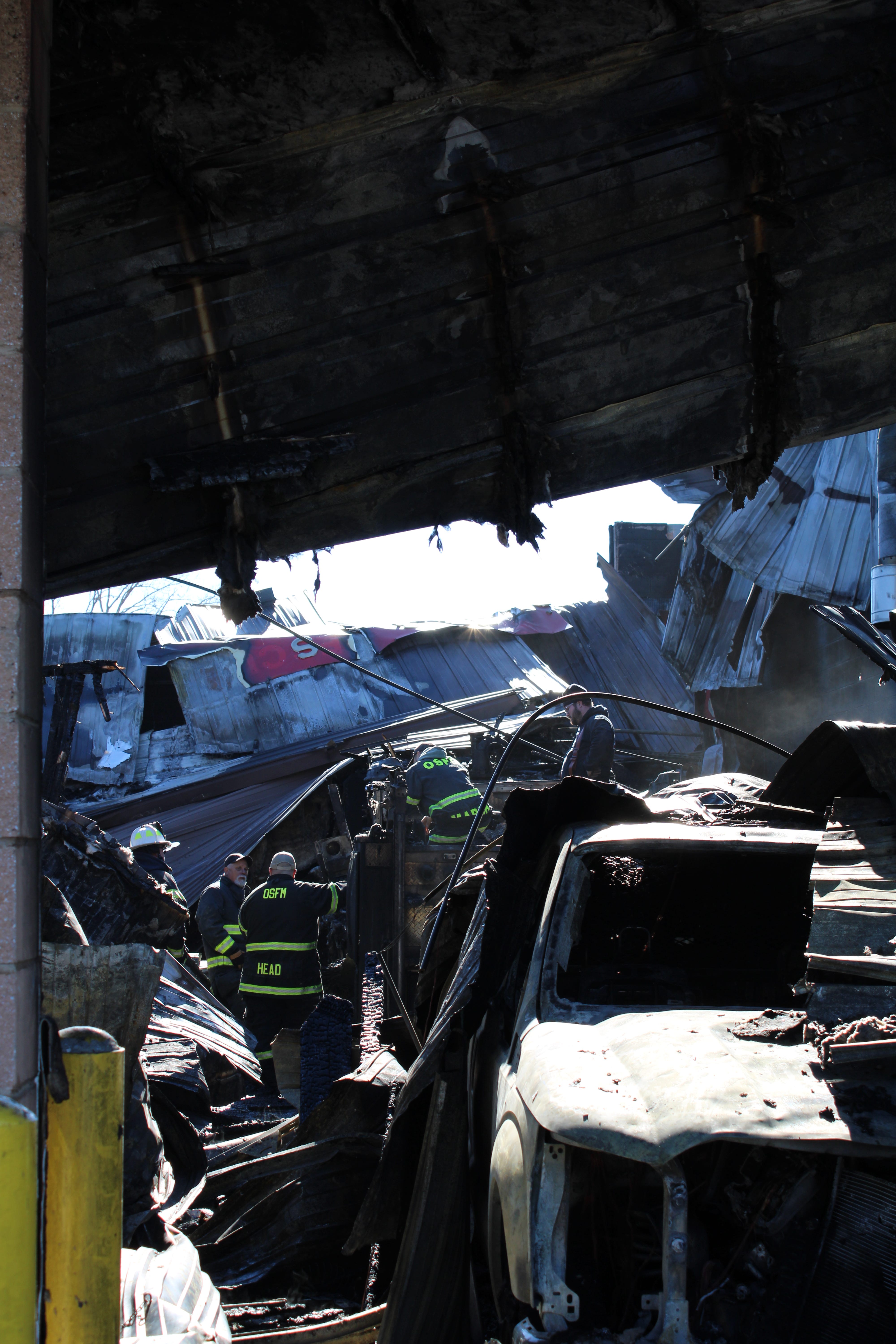Office of the State Fire Marshal investigators stand amid the rubble of Mills River Fire Department Station 2, which was completely lost in an early morning fire Jan. 17, 2025. State and local officials are investigating the cause.