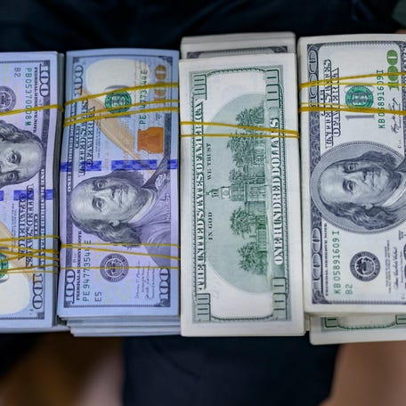 A teller shows US dollar bills at an exchange office at the Grand Bazaar in Istanbul on November 28, 2024.