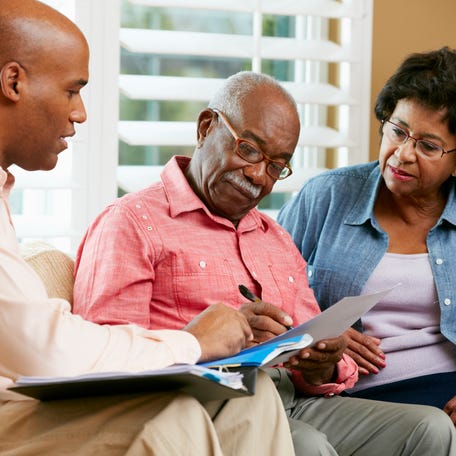 Financial Advisor Talking To Senior Couple At Home Signing Documents Sitting On Sofa  Credit: monkeybusinessimages, Getty Images/iStockphoto  GETTY ID#: GettyImages-177733410.jpg