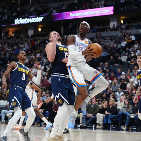 Oklahoma City Thunder guard Shai Gilgeous-Alexander (2) attempts a shot against Denver Nuggets center Nikola Jokic (15).