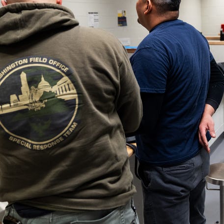 A U.S. Immigration and Customs Enforcement (ICE) agent fingerprints a migrant after he was apprehended in Virginia on Jan. 15, 2025.